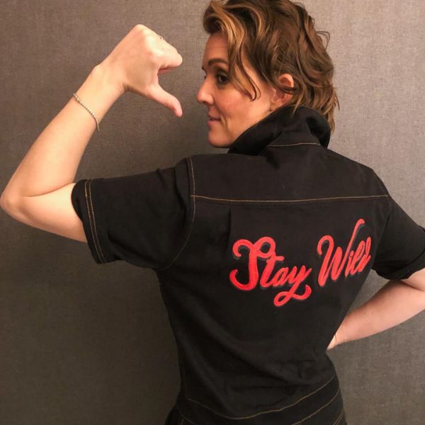 Person wearing black coverall showing customized back that says "Stay Wild" in red thread.