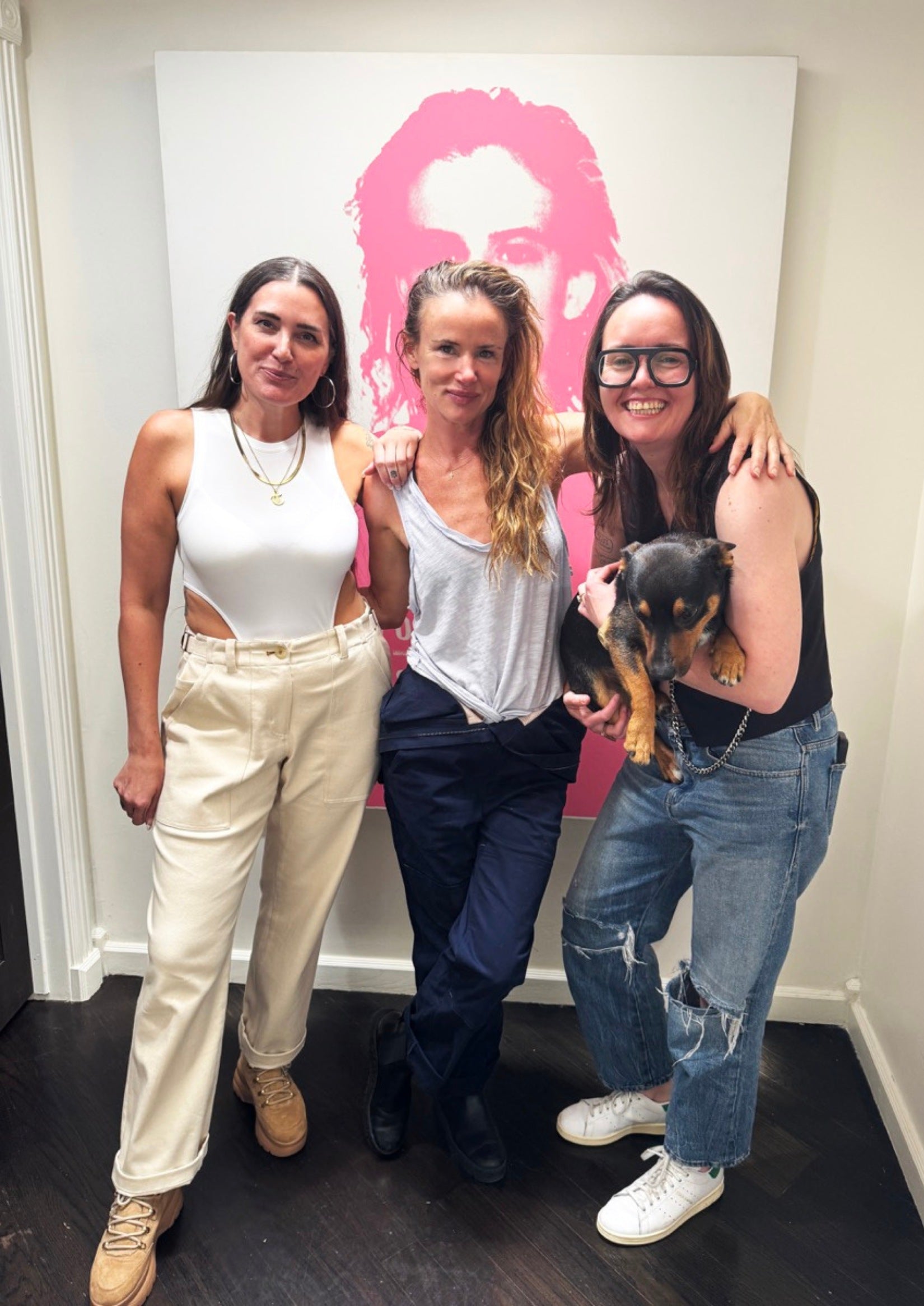 Tara and Emma from WIldfang pose for a picture with Juliette Lewis in front of white wall.