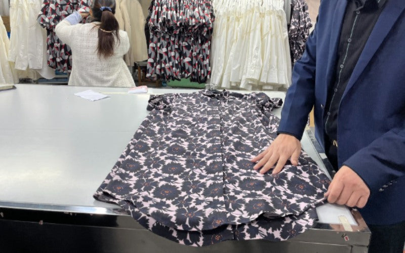 Close up of button up that was just sewn being inspected at manufacturing facility.