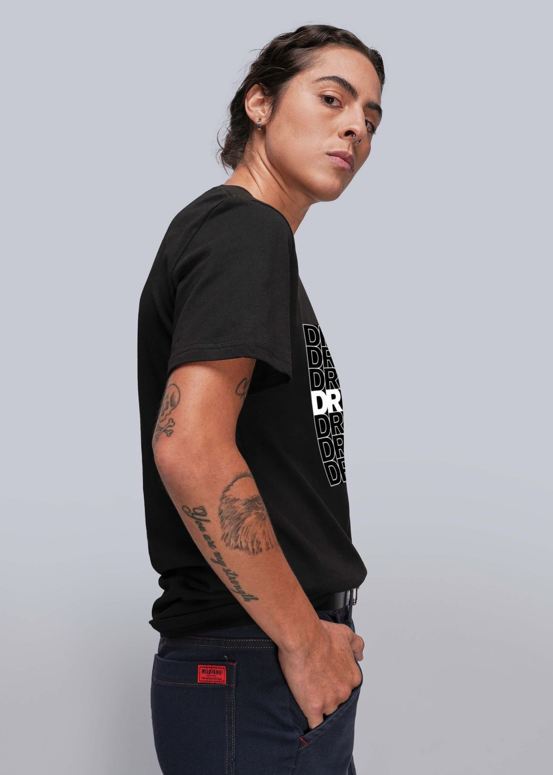 S=Person wearing a black t-shirt with white text on a light gray background