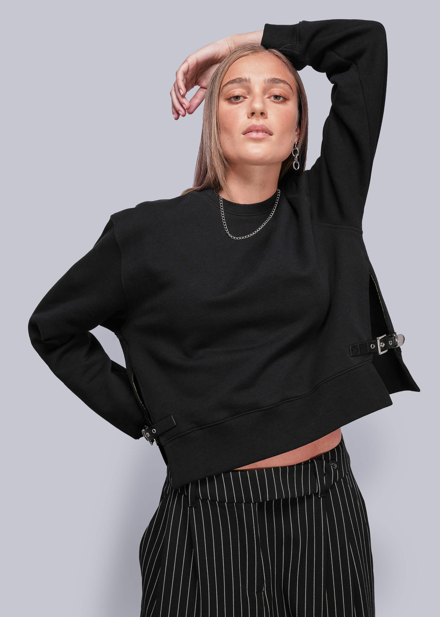 S=Person wearing a black sweatshirt with a plain background