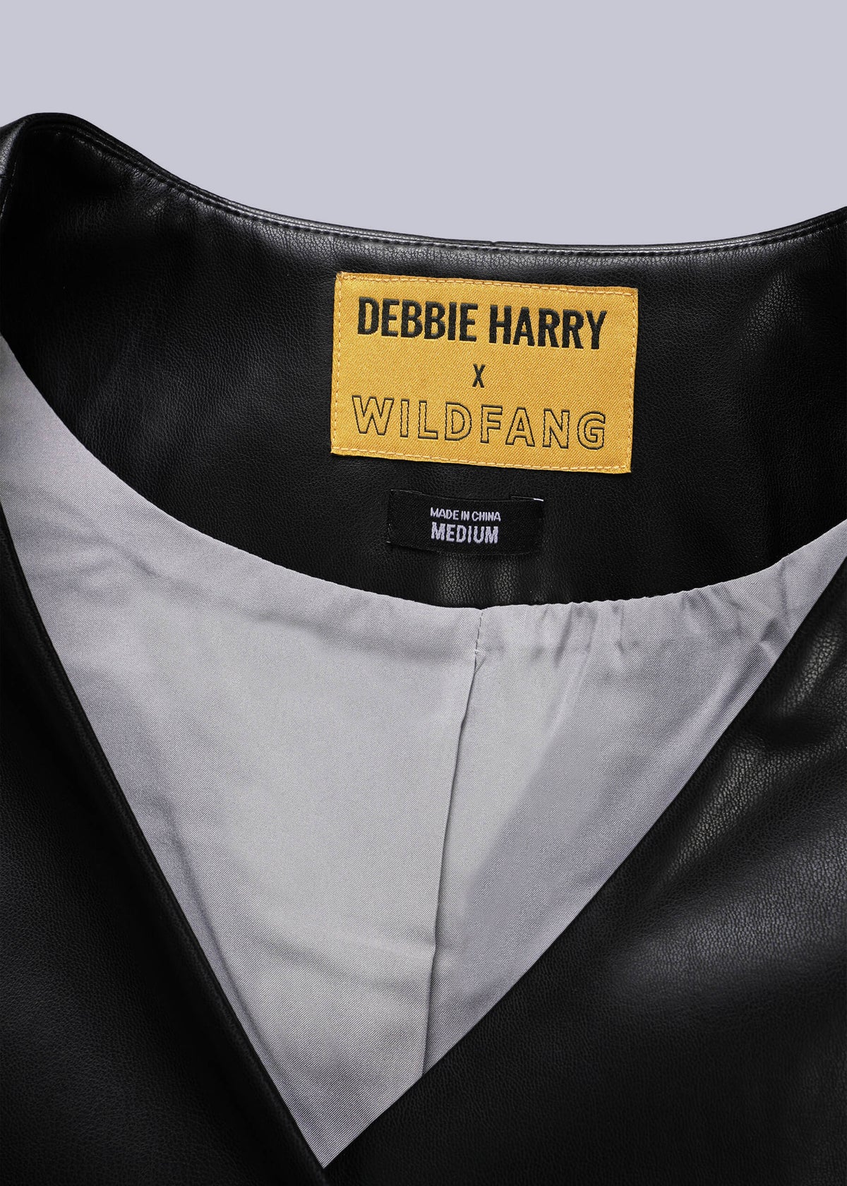 Close-up of a black leather vest with a label reading 'Debbie Harry x Wildfang'.
