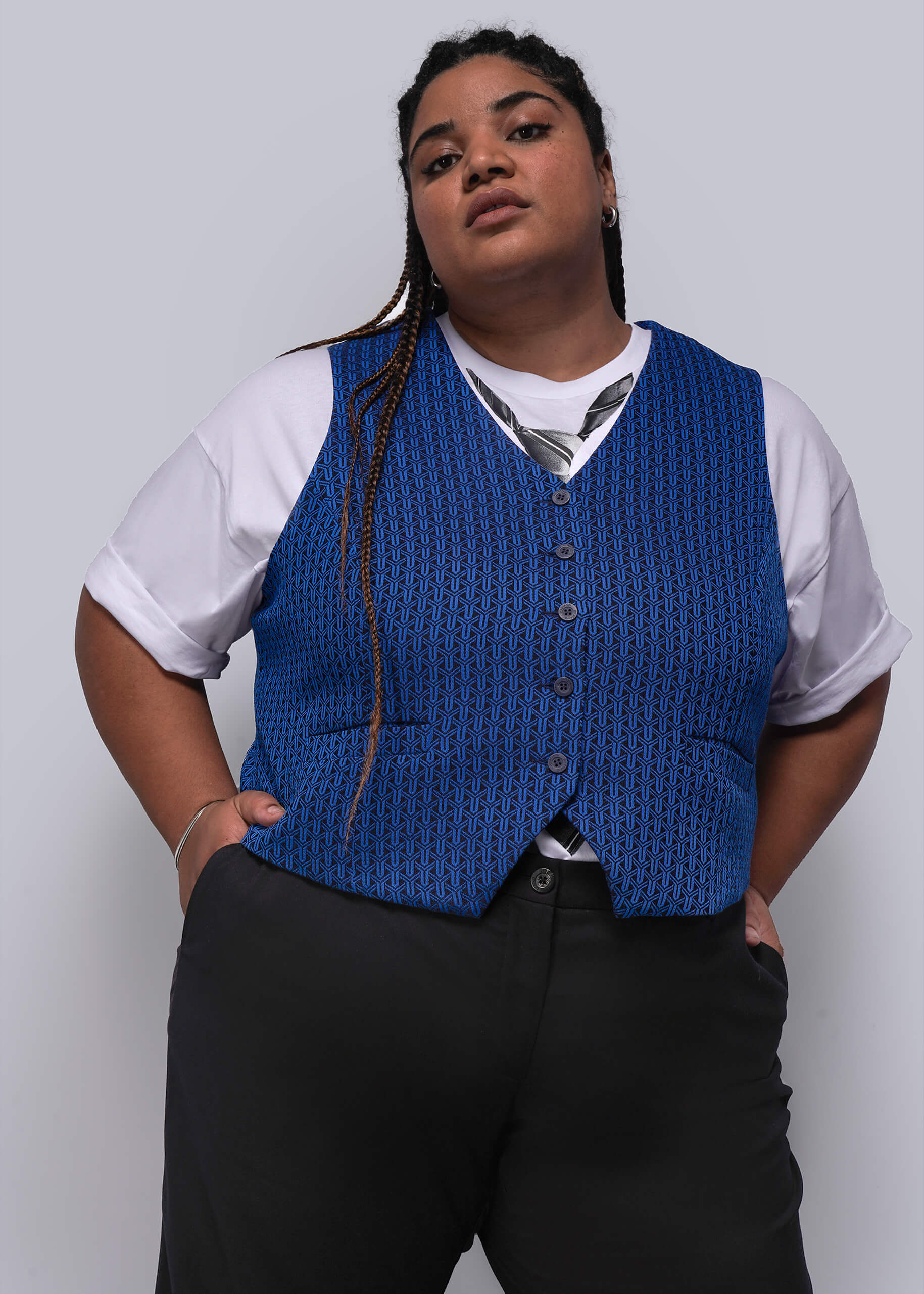1X=Person wearing a blue vest over a white shirt with a gray background