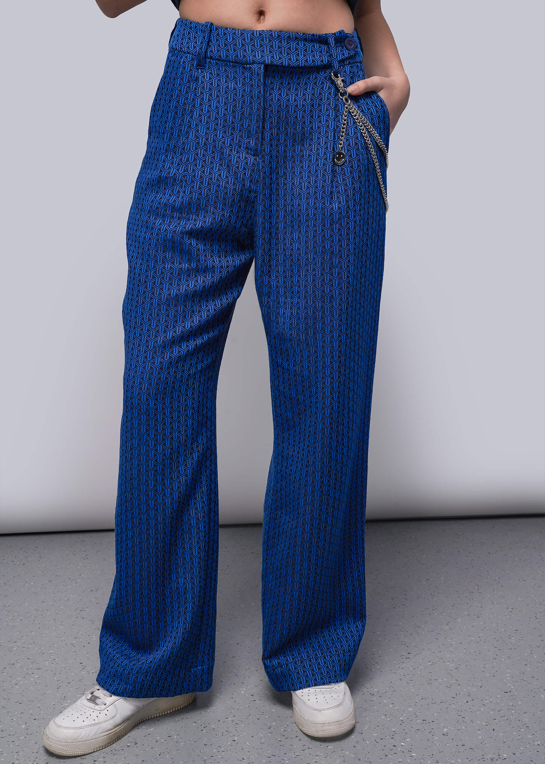 S=Person wearing blue patterned pants on a plain background