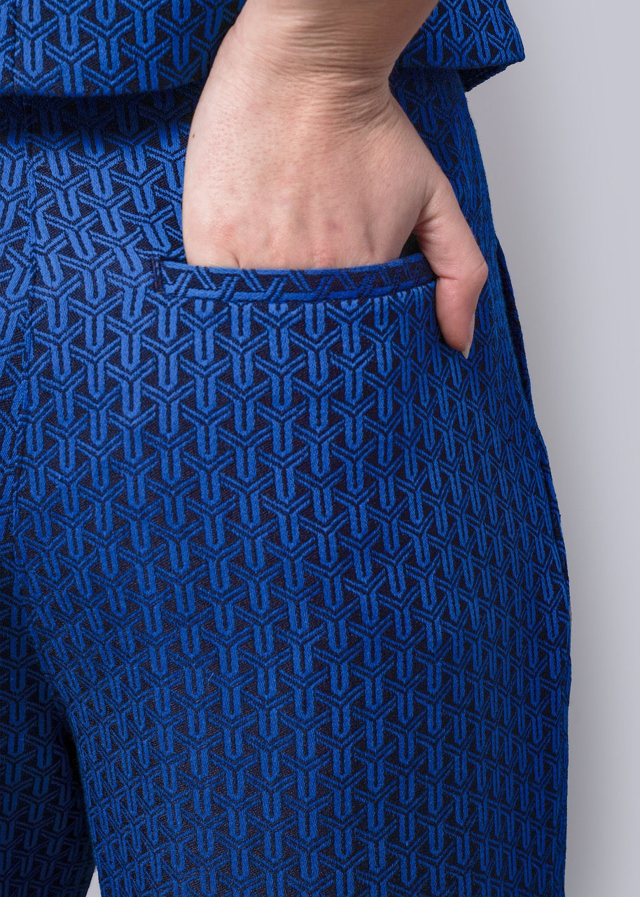 S=Close-up of a person wearing a blue patterned pants with a plain background
