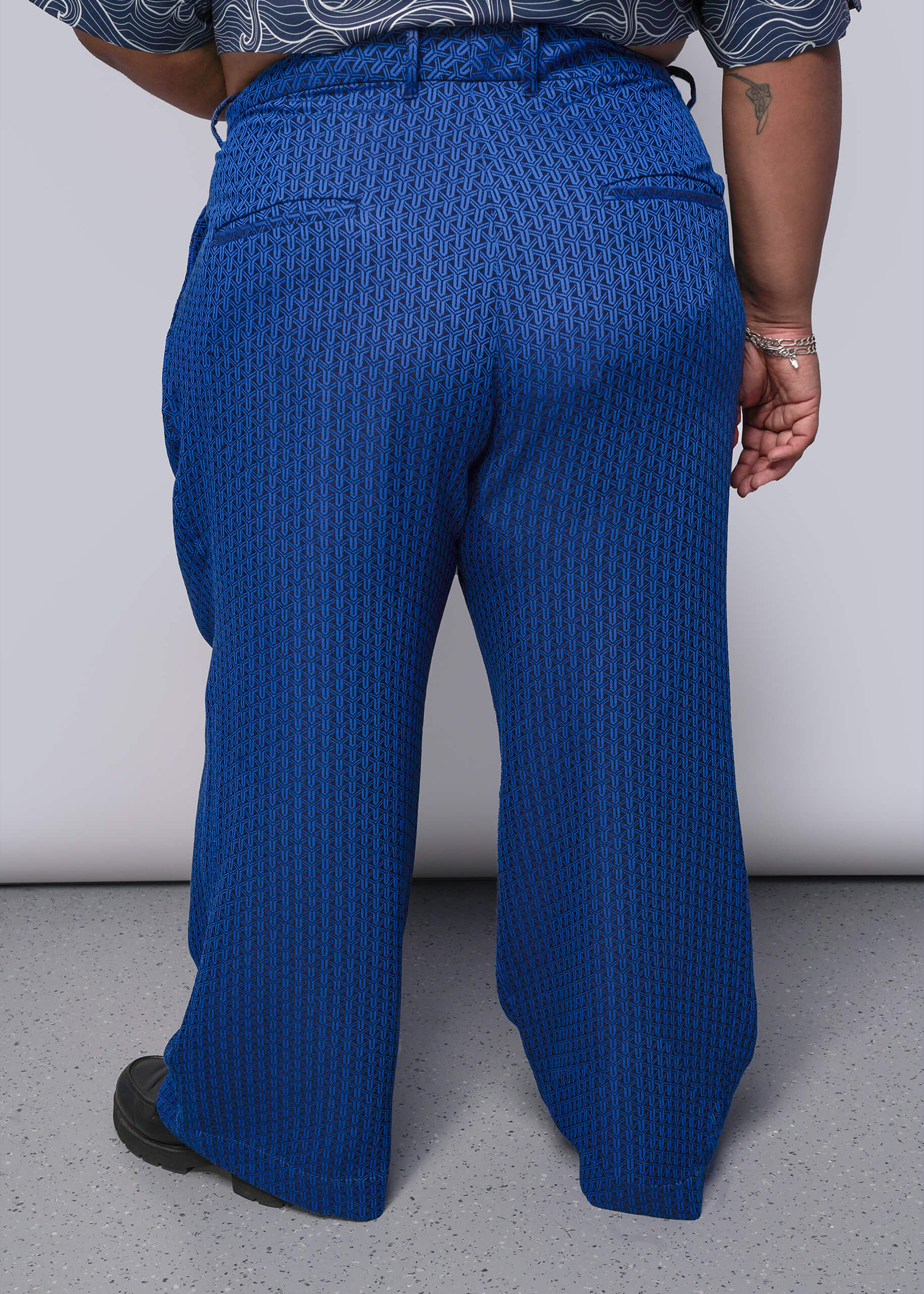 1X=Person wearing blue textured pants from behind on a plain background