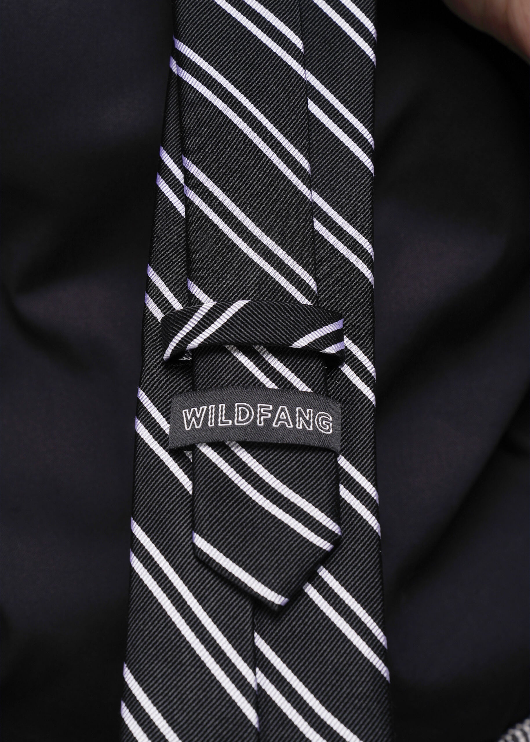 Black tie with white stripes and 'WILDFANG' label on a black background