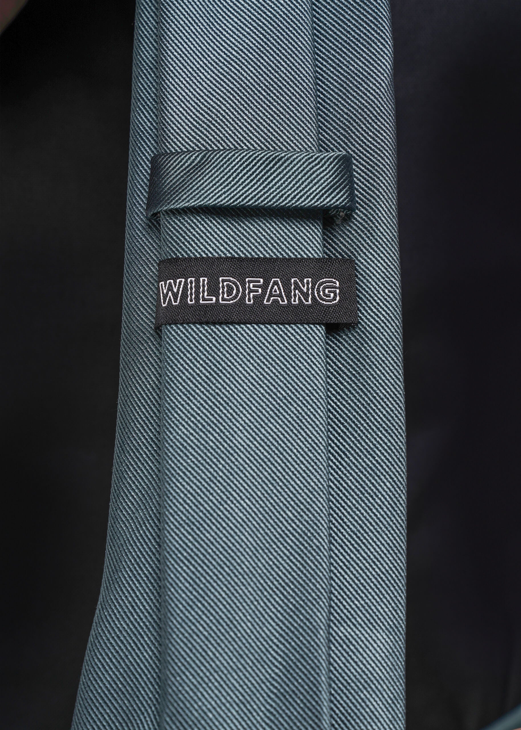 Blue tie with 'WILDFANG' label on a dark background