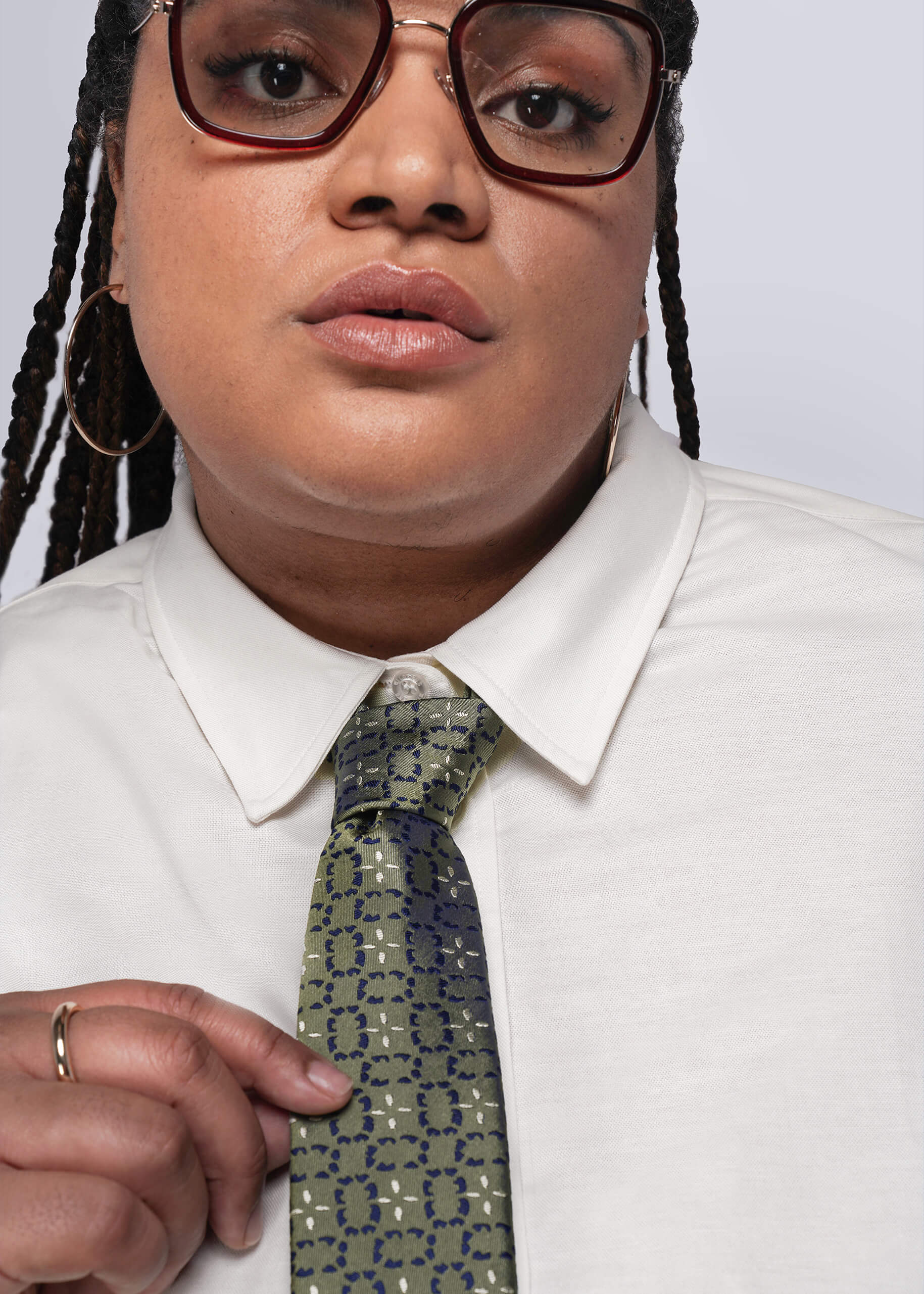 Person wearing a white shirt and patterned tie against a plain background