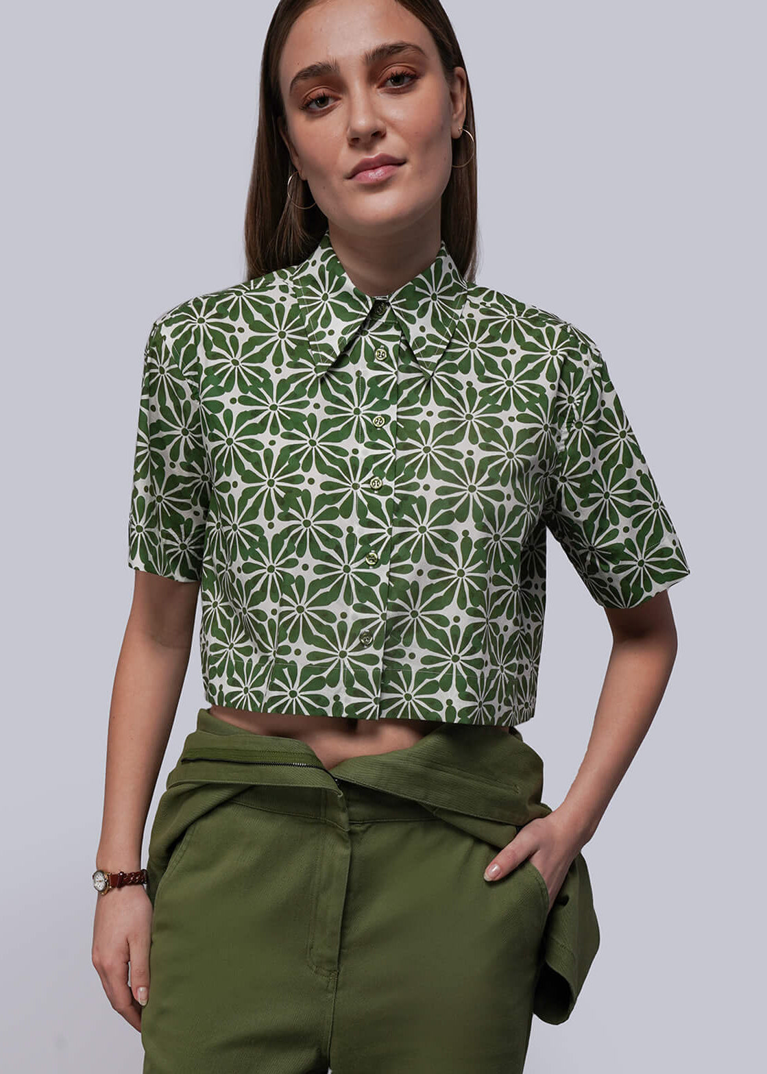 S=Person wearing a green patterned shirt and green pants against a plain background