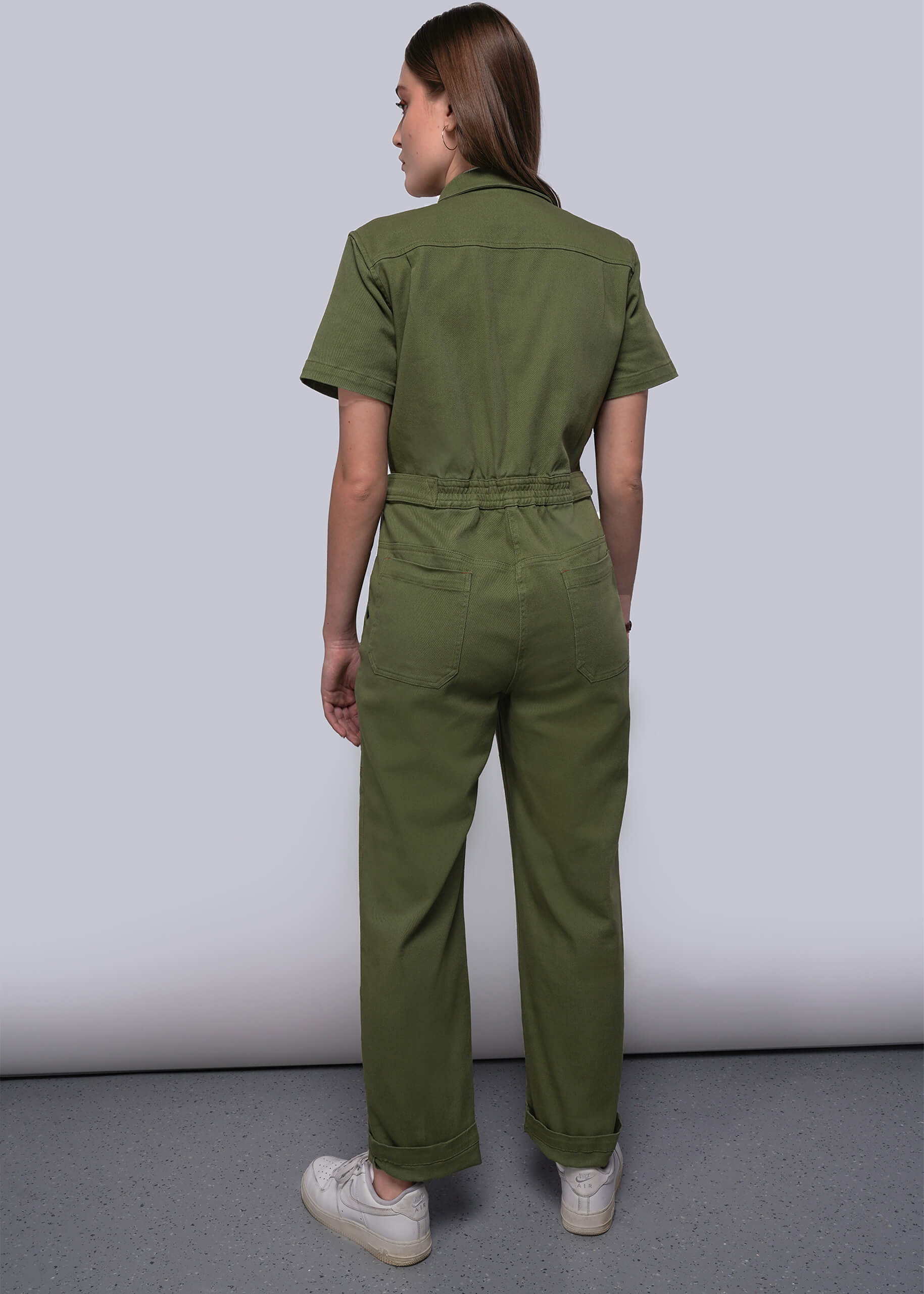S=Person wearing a green jumpsuit on a plain background
