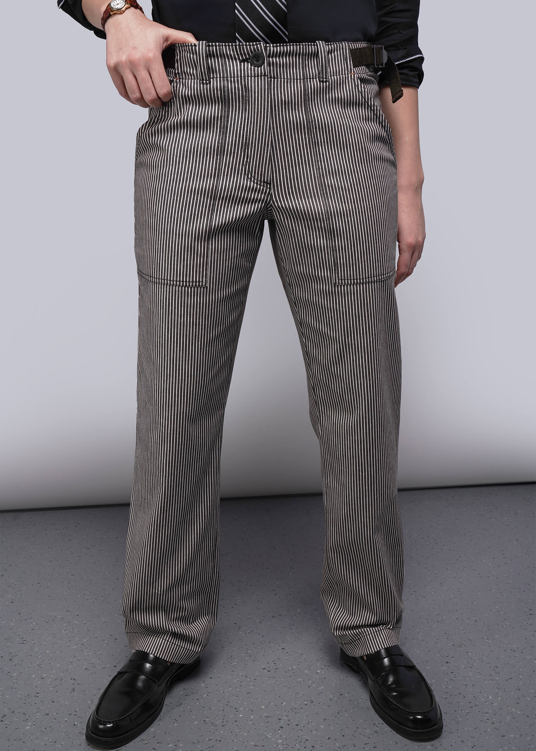 Person wearing brown and white striped pants on a plain background
