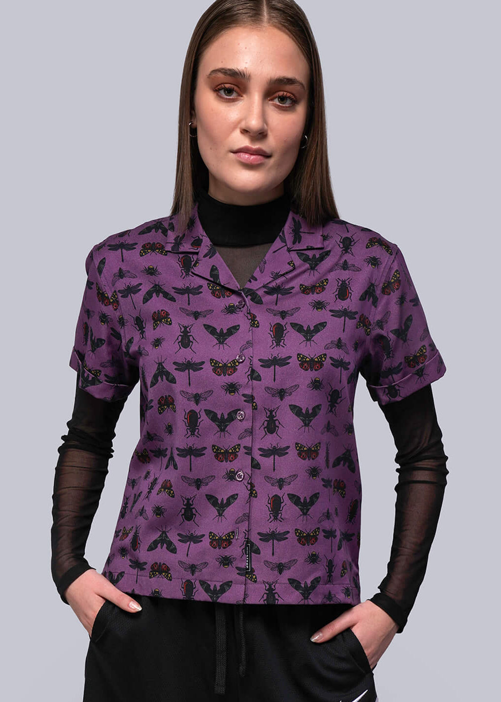 S=Person wearing a purple patterned shirt and black shorts with a Nike logo.