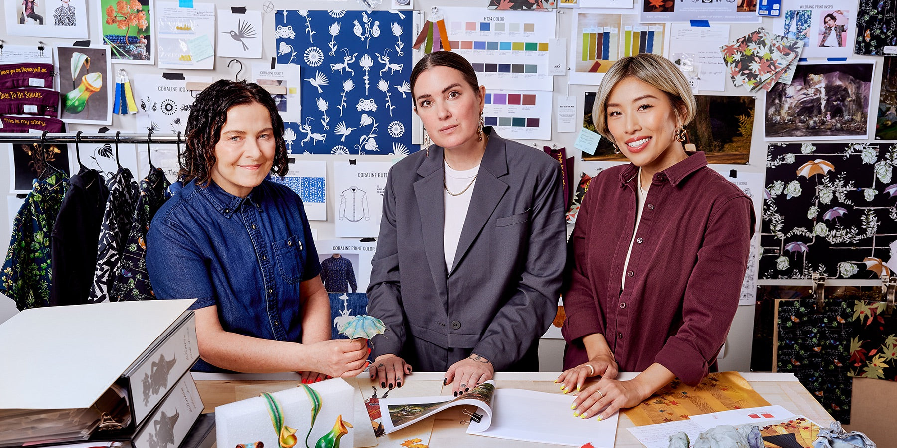Picture of Laika and Wildfang team members Deb Cook, Taralyn Thuot 
Yoshie Kurkowski in front of mood board inspiring Laika x Wildfang collection.