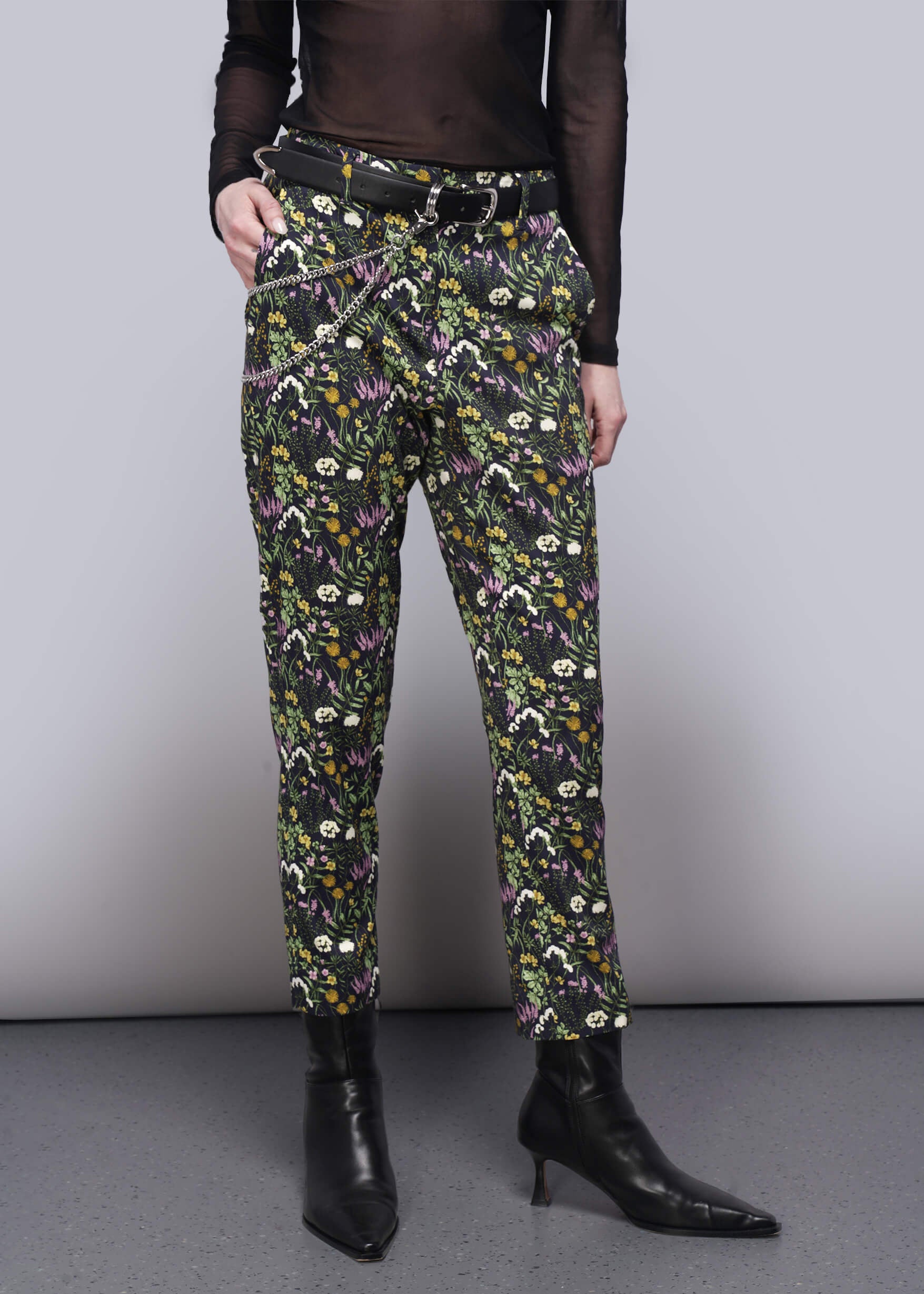 Floral patterned pants worn by a person on a plain background