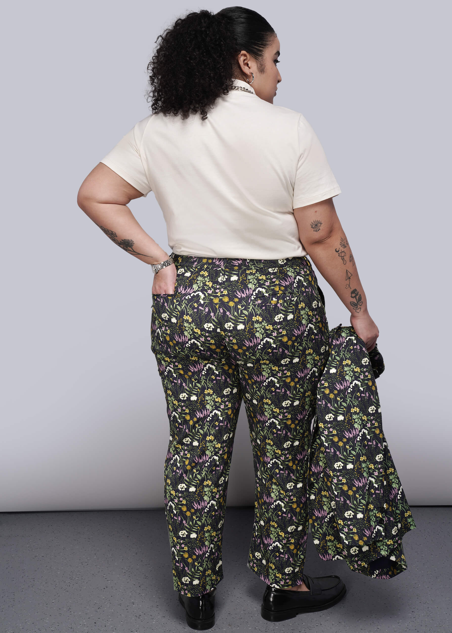 1X=Person wearing a white shirt and floral pants against a plain background