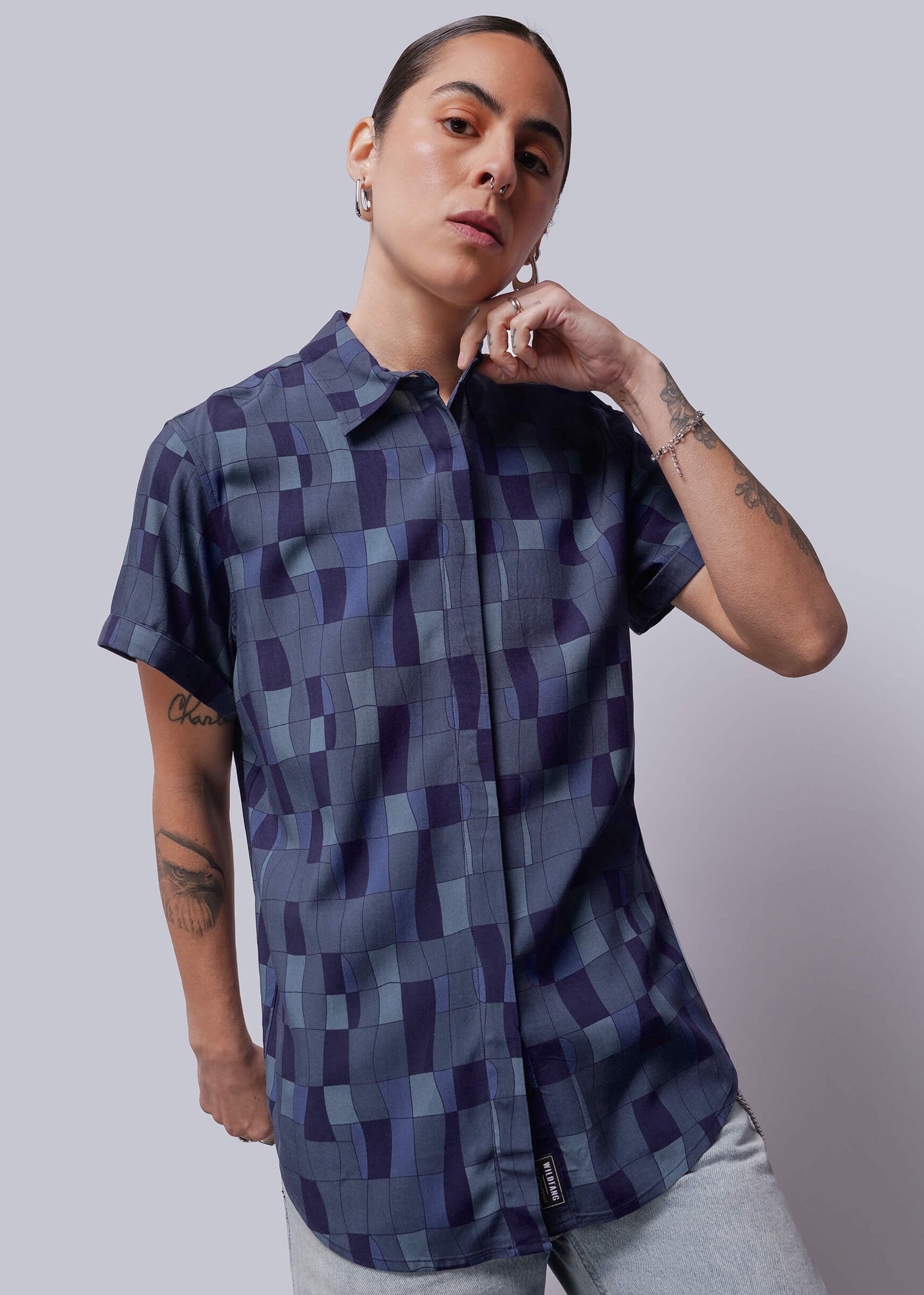 S=Person wearing a patterned shirt against a plain background