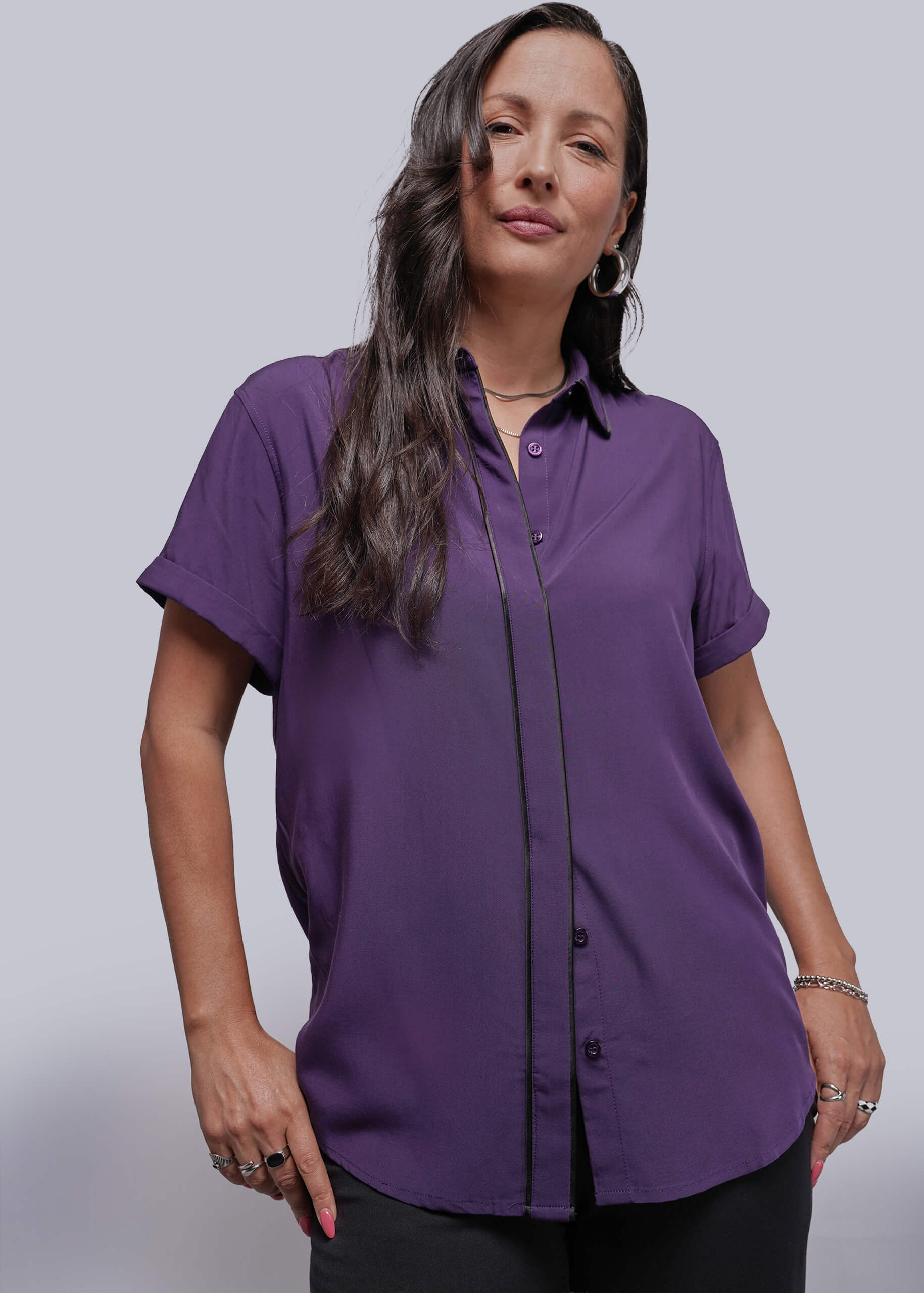 Woman wearing a purple shirt against a plain background