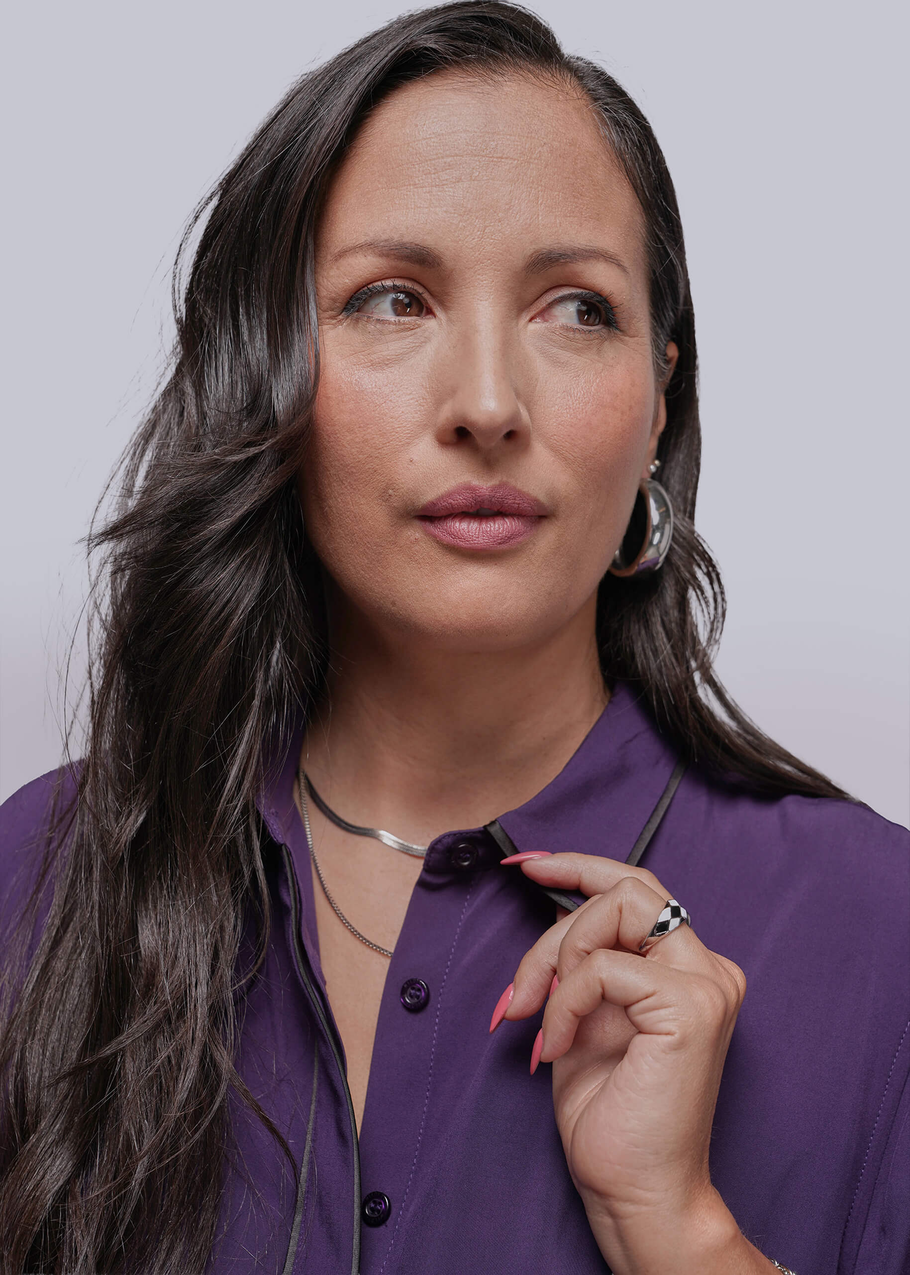 Woman wearing a purple shirt against a plain background