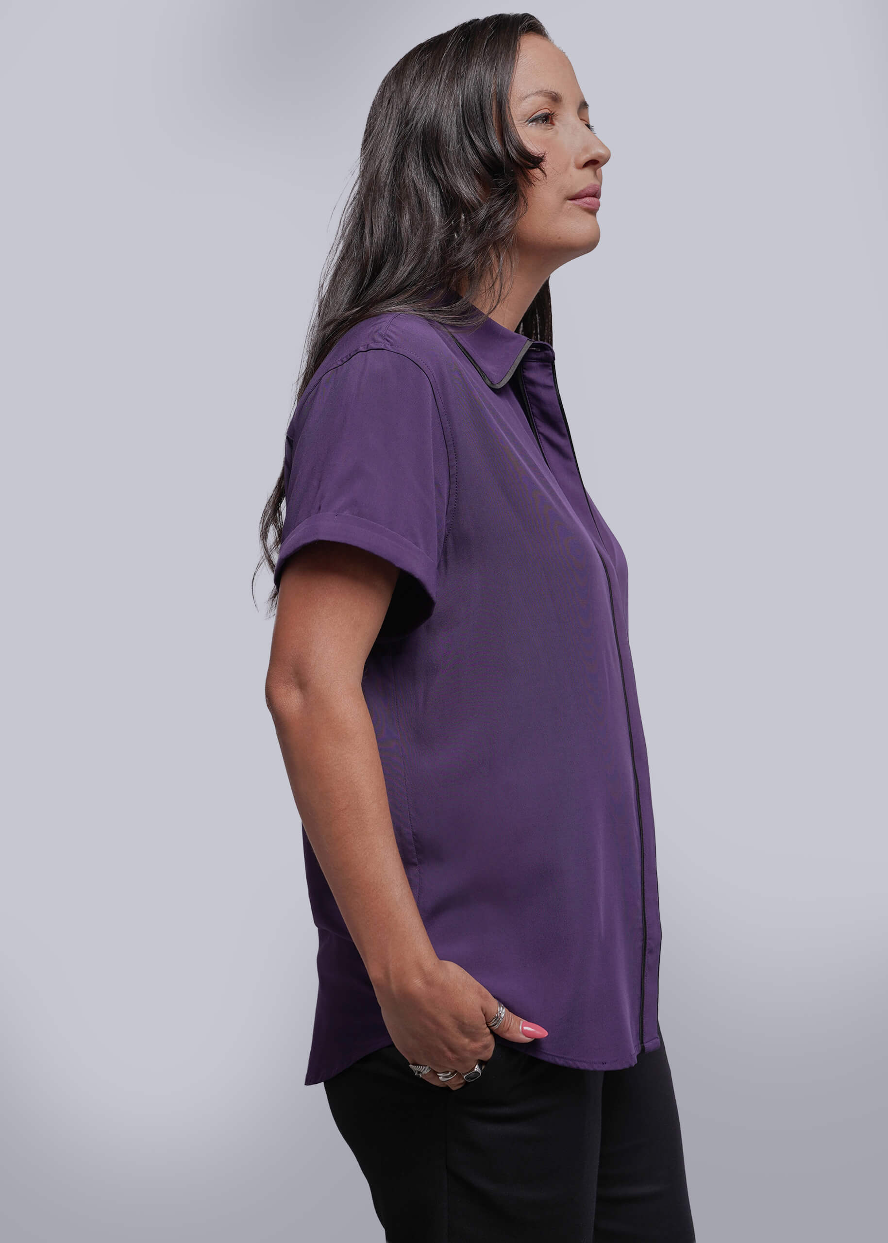 S=Woman wearing a purple shirt against a plain background