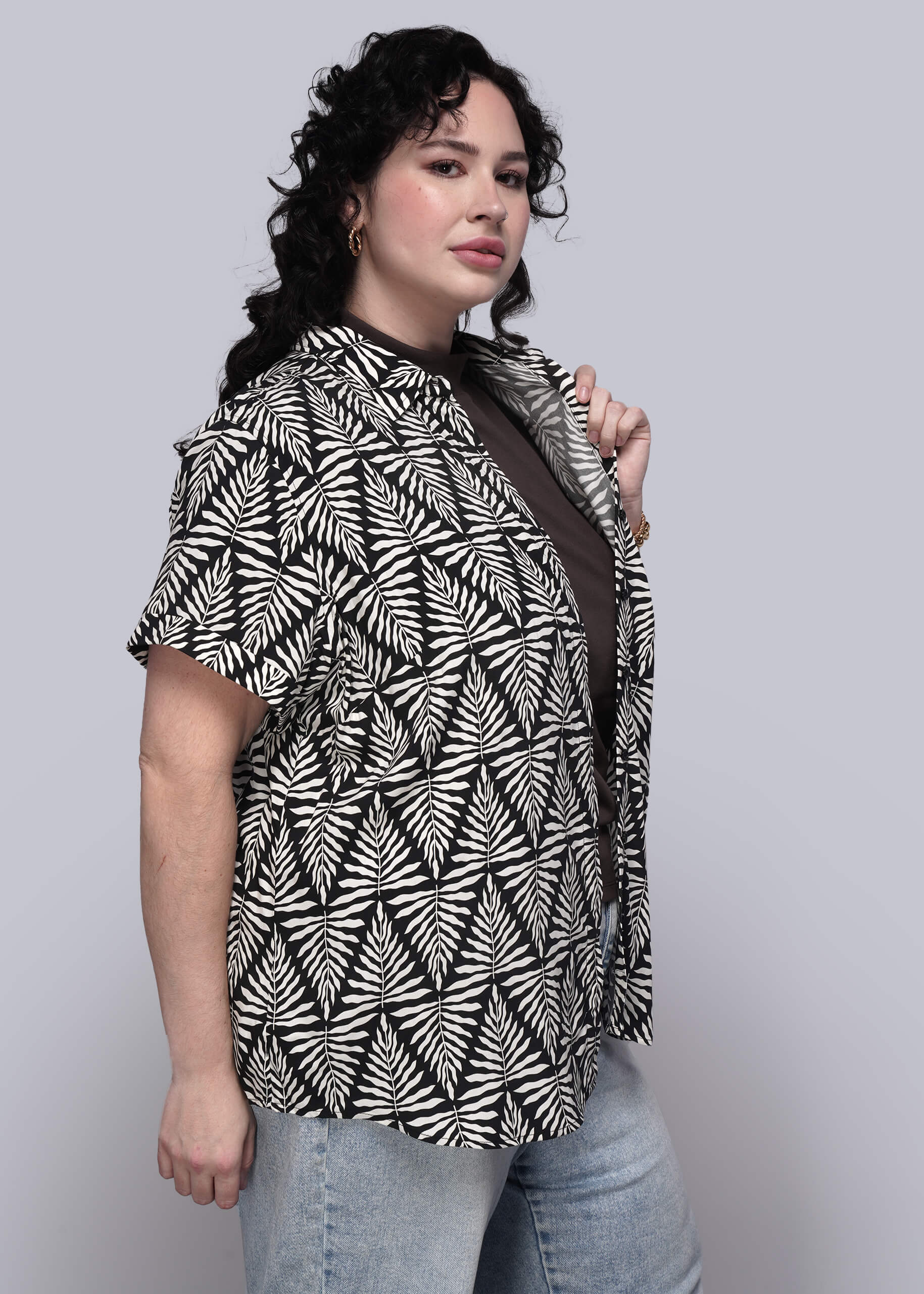 1X=Person wearing a black and white patterned top against a plain background