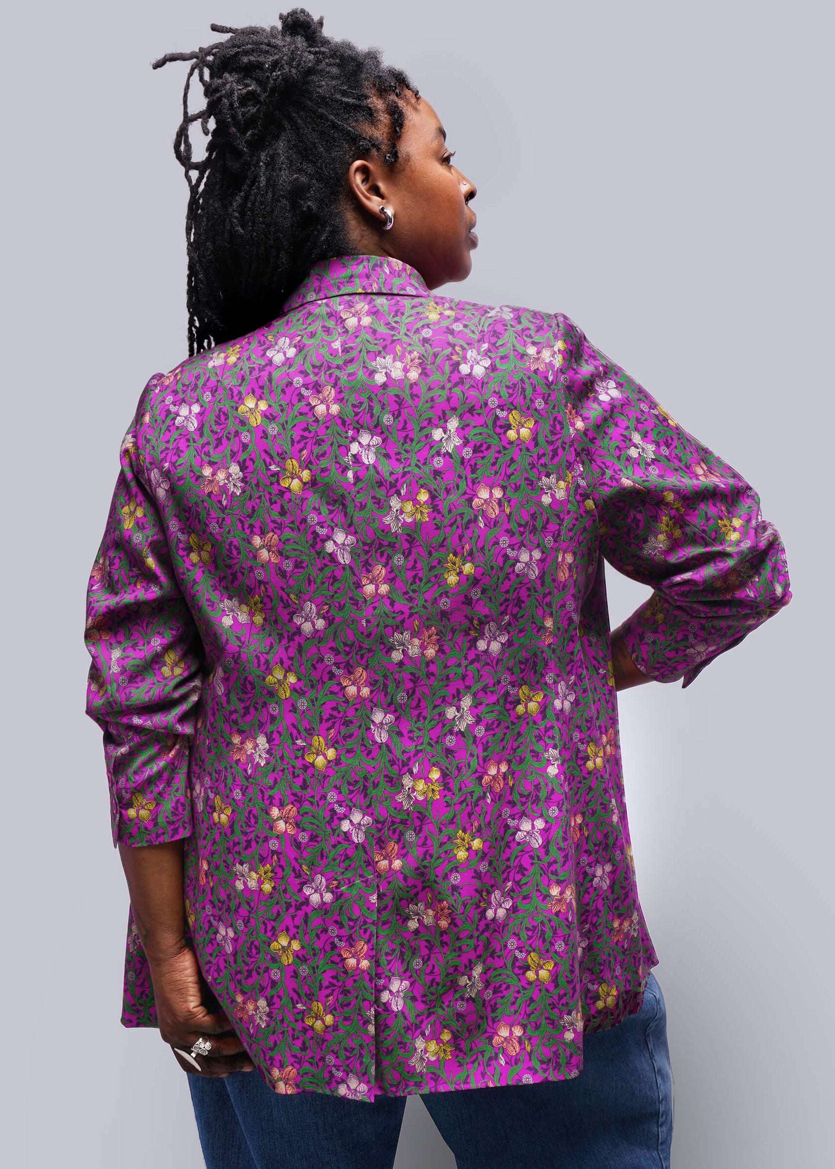 1X=Person wearing a floral patterned jacket on a plain background