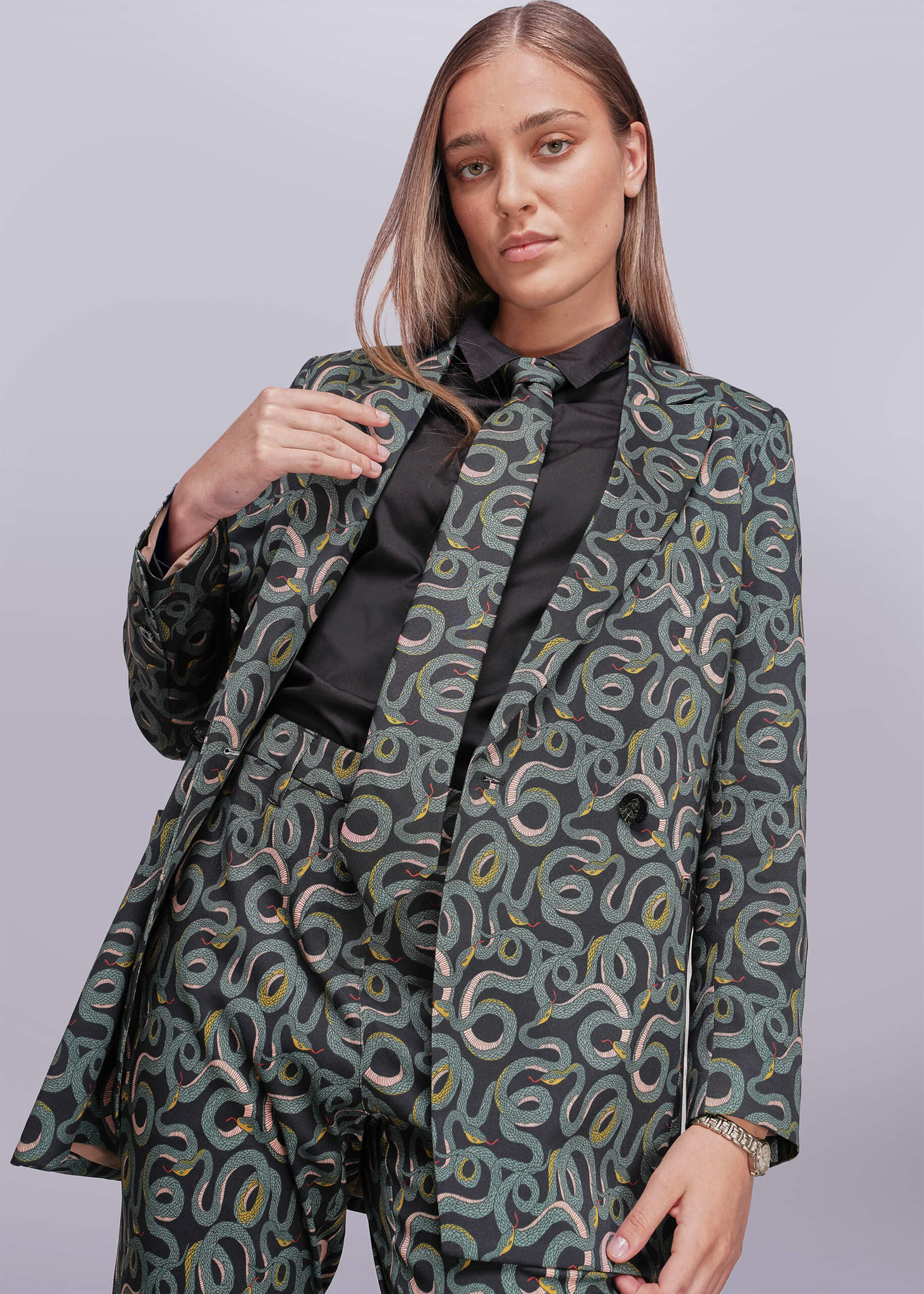 Woman wearing a snake patterned suit with a plain background