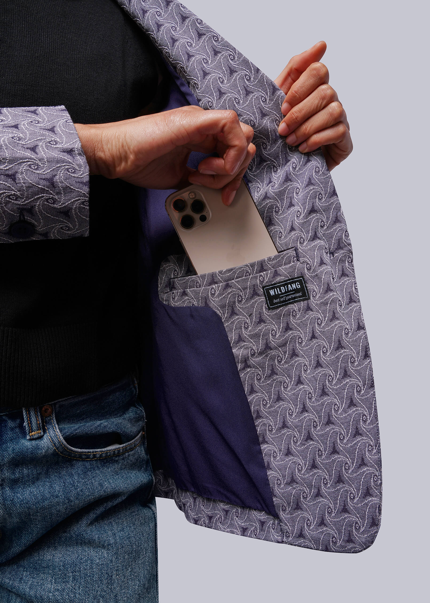 S=Person holding a phone in a patterned jacket interior pocket with a visible brand label.