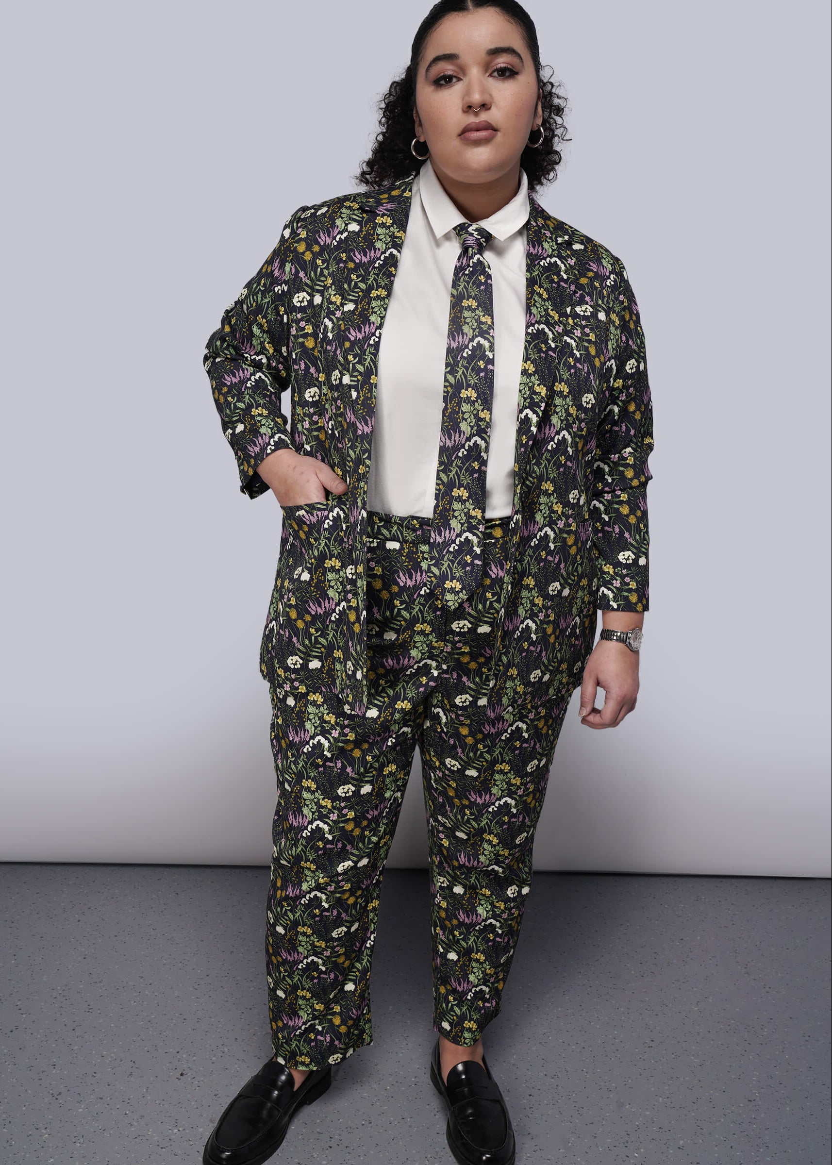 1X=Person wearing a floral suit and tie with a plain background