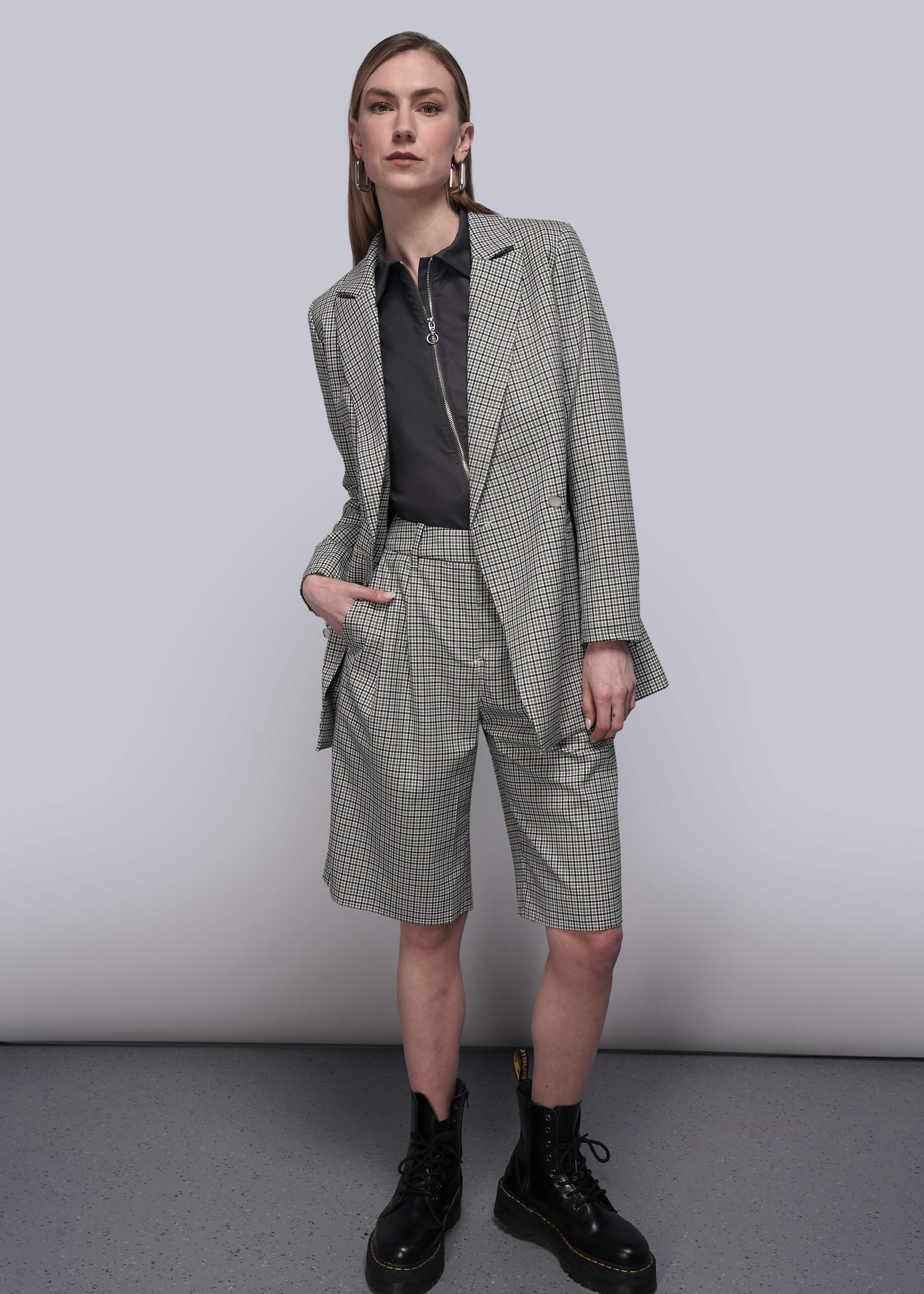 S=Person wearing a checkered suit with shorts and black boots on a plain background