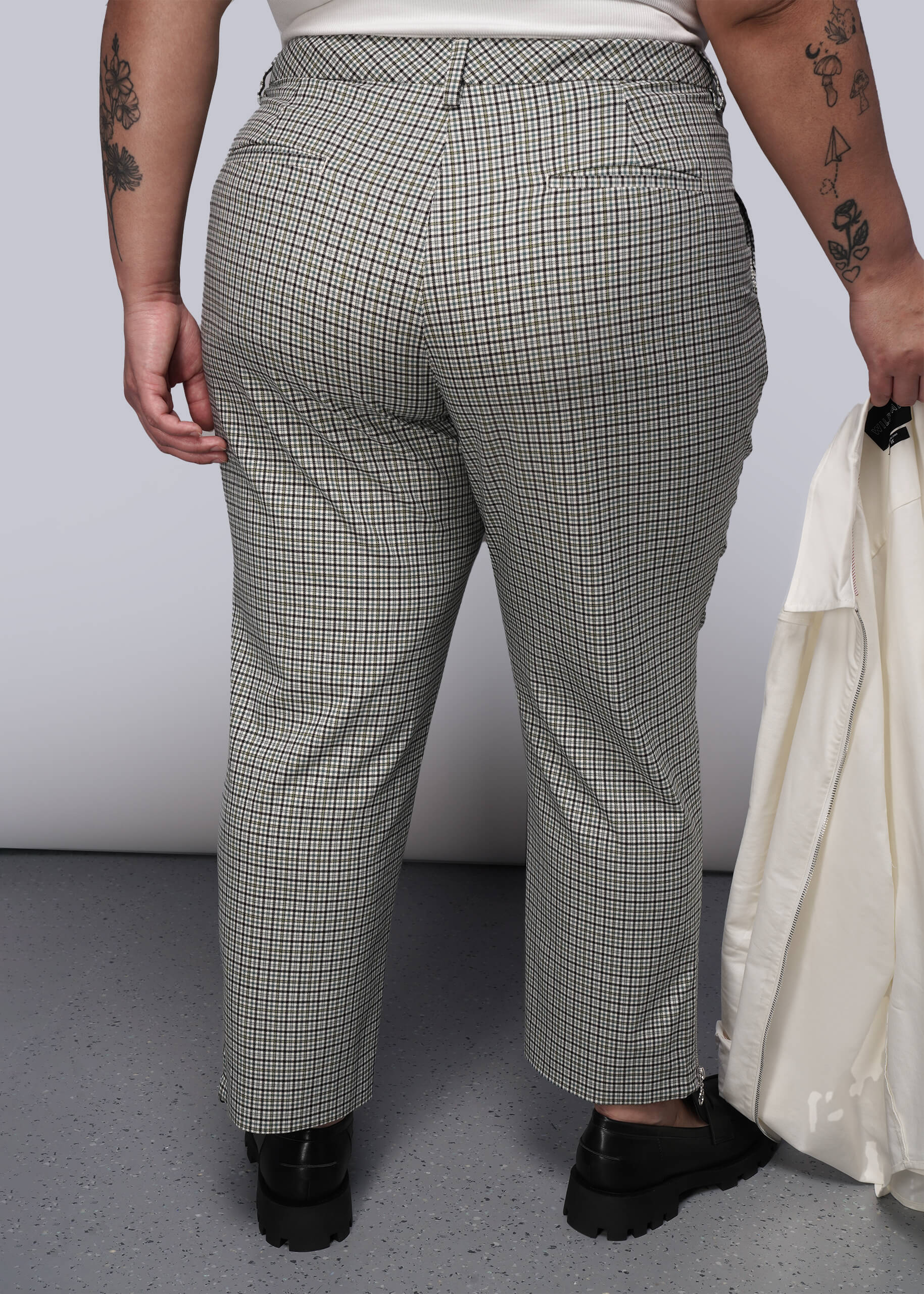 1X=Back of person wearing plaid pants with a plain background