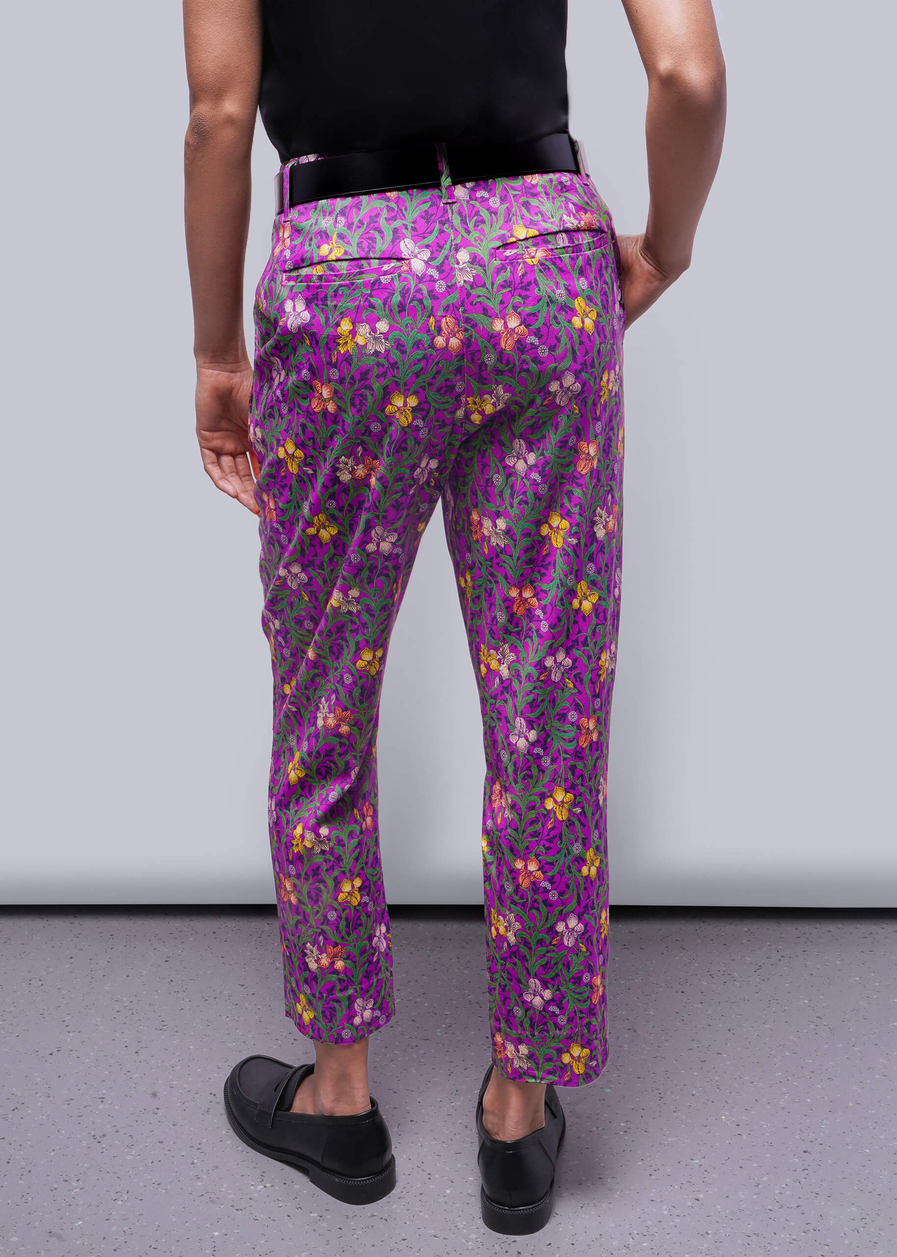 S=Person wearing purple floral pants against a plain background