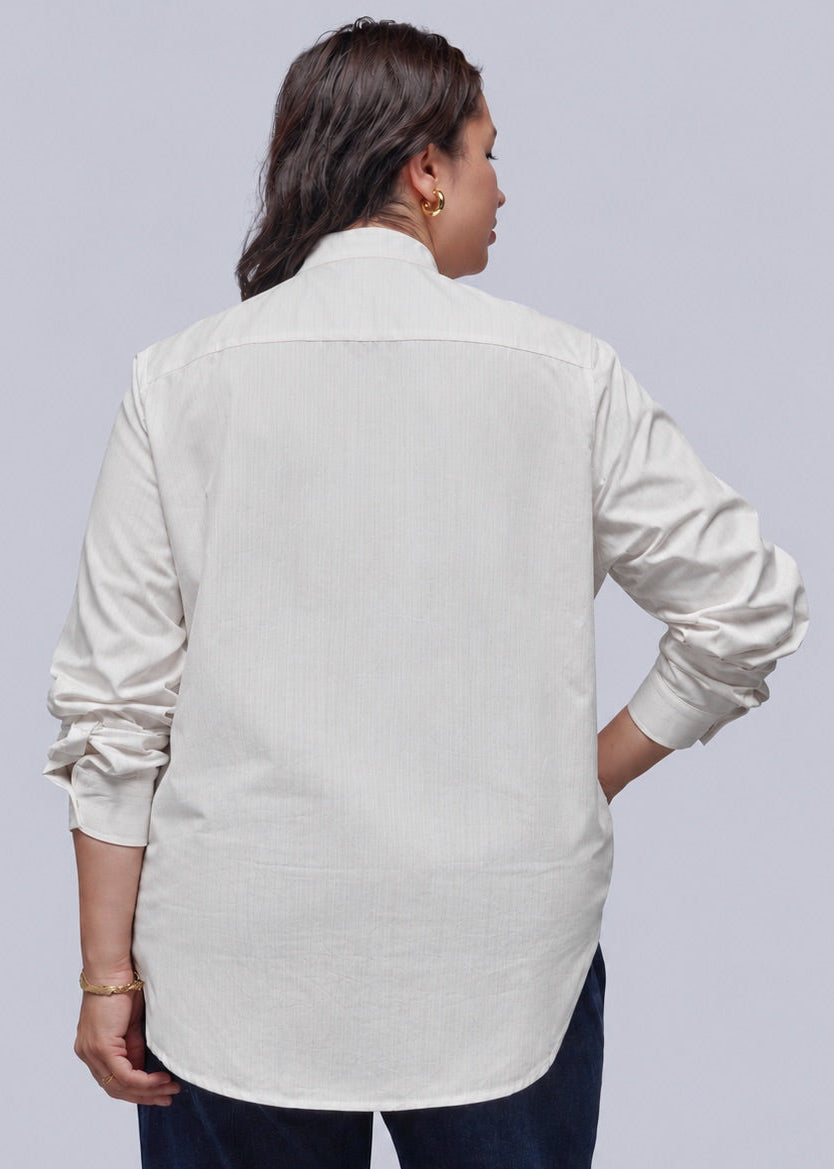 1X=A person shown from the back wearing a light cream-colored long-sleeve button-up shirt and dark navy pants, set against a solid light gray background.