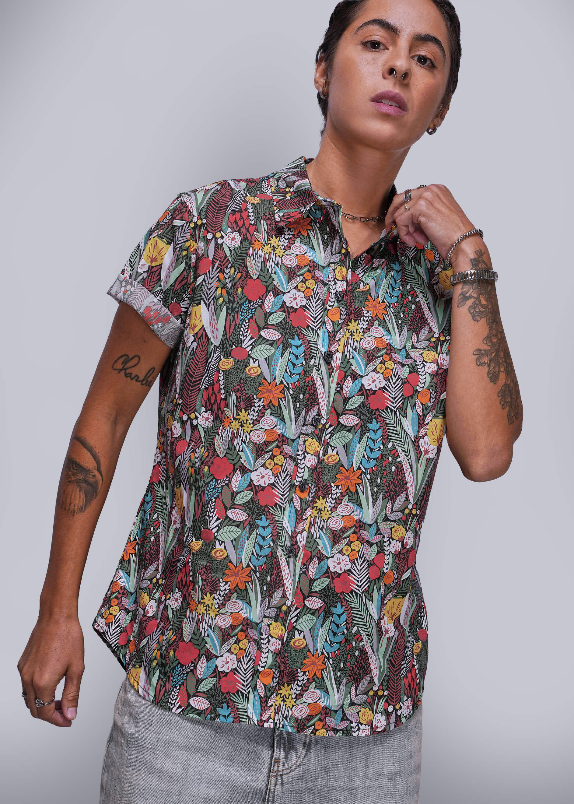 S=Person wearing a colorful floral patterned shirt against a plain background