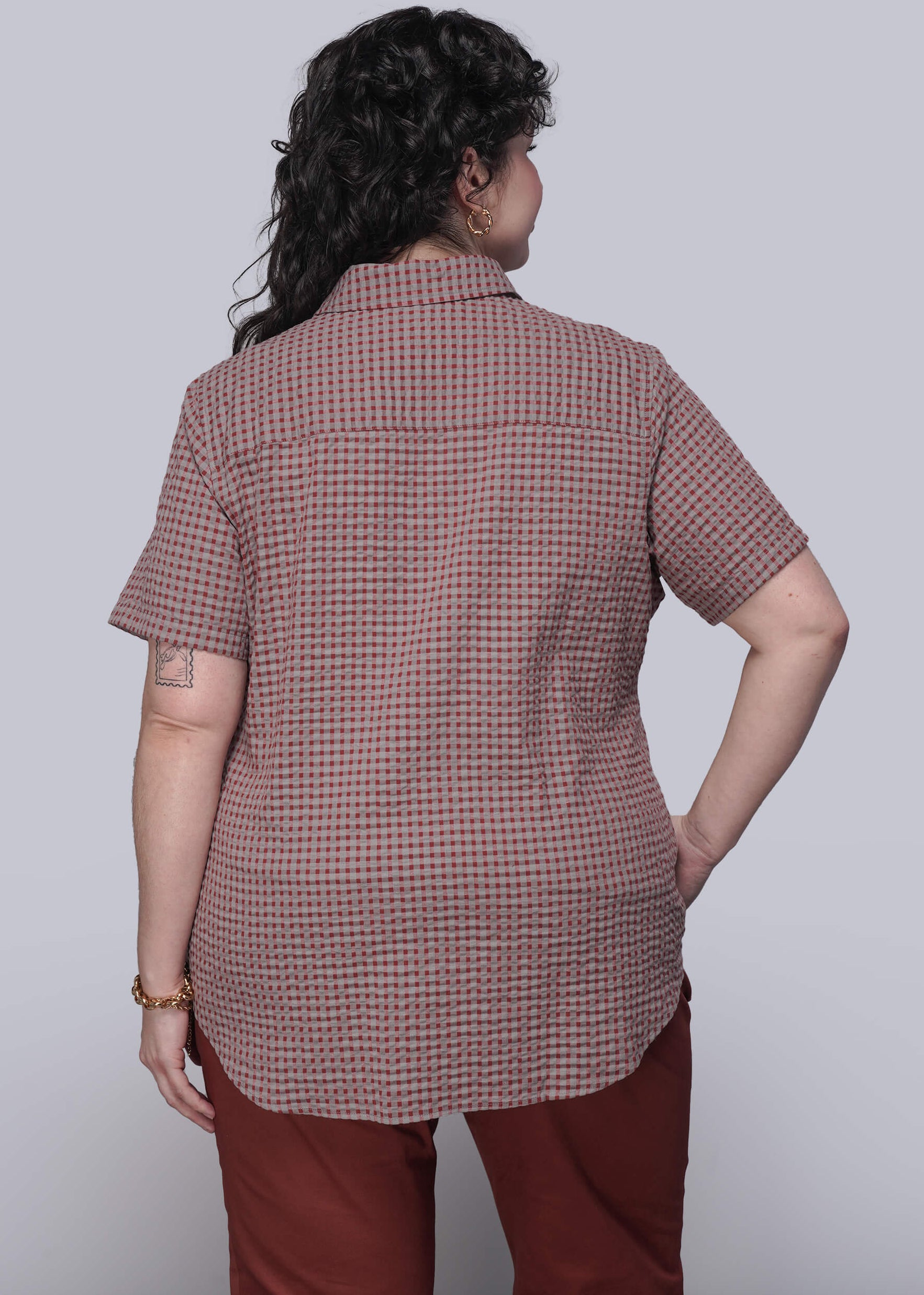 1X=Person wearing a checkered shirt and red pants on a white background