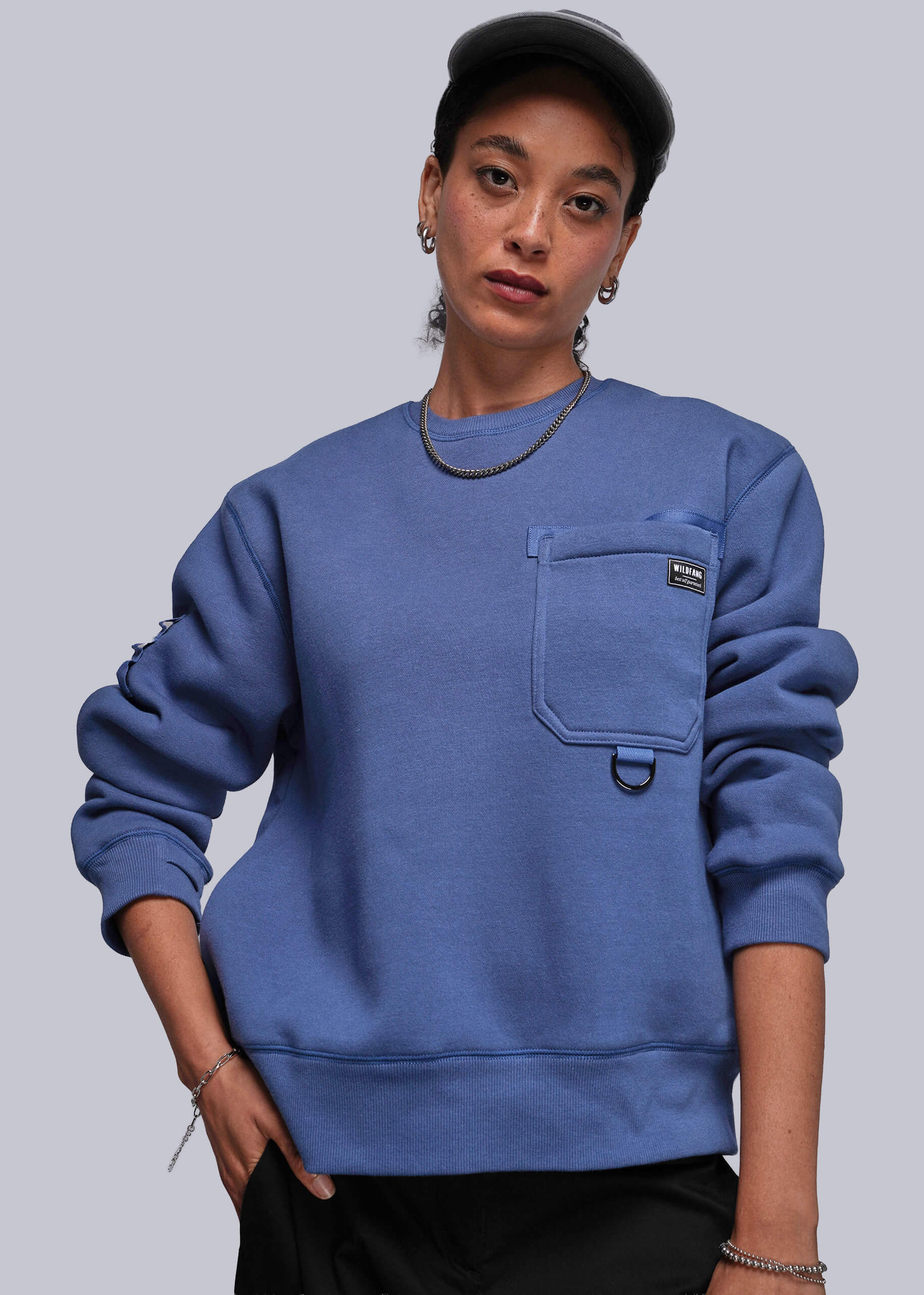 S=Person wearing a blue sweatshirt with a pocket on a plain background