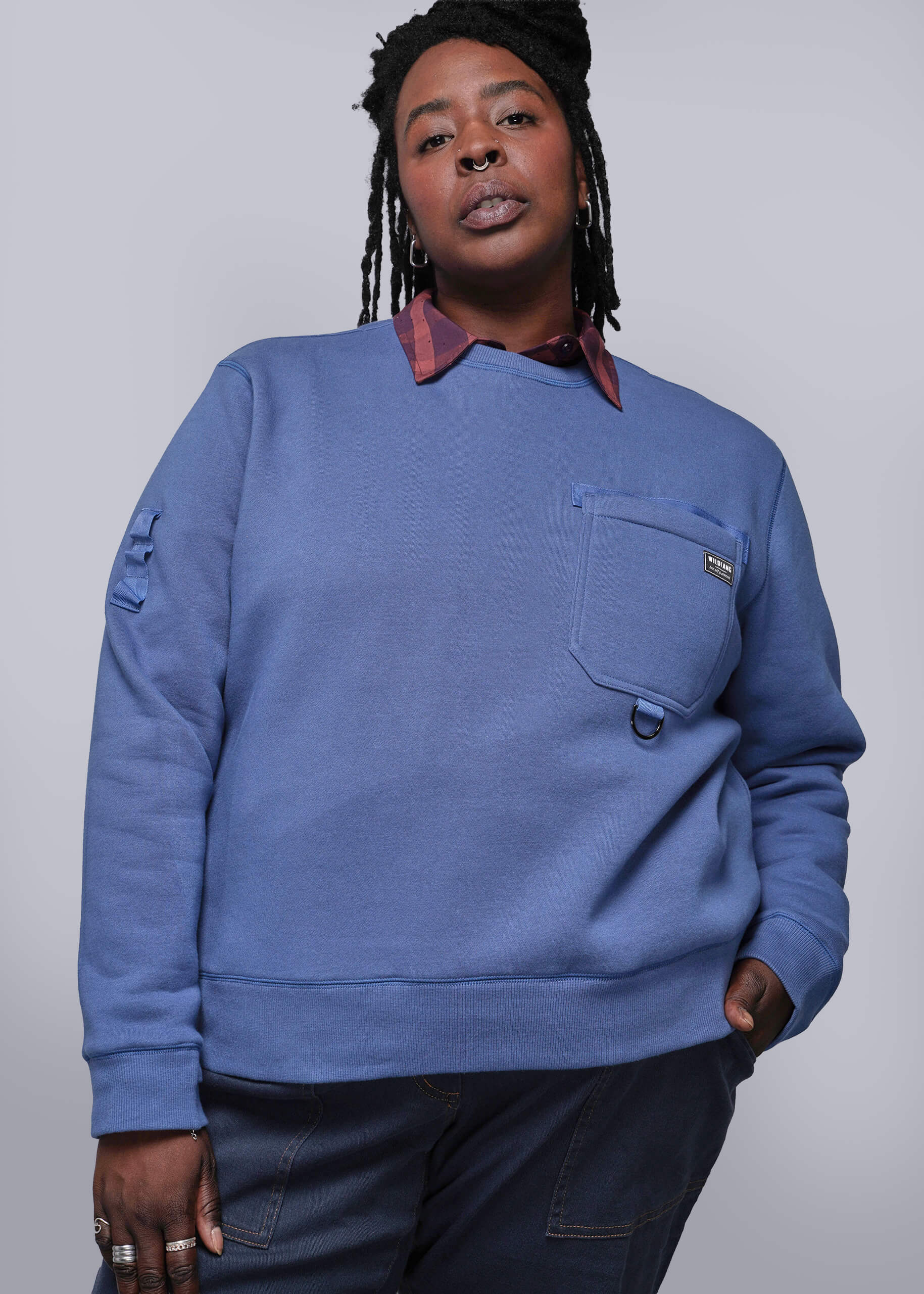 1X=Person wearing a blue sweatshirt with a plain background