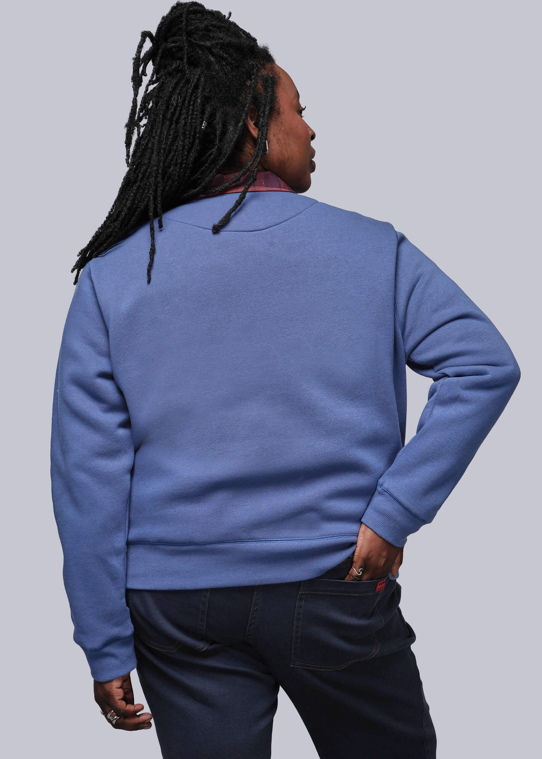 1X=Person wearing a blue sweatshirt against a plain background