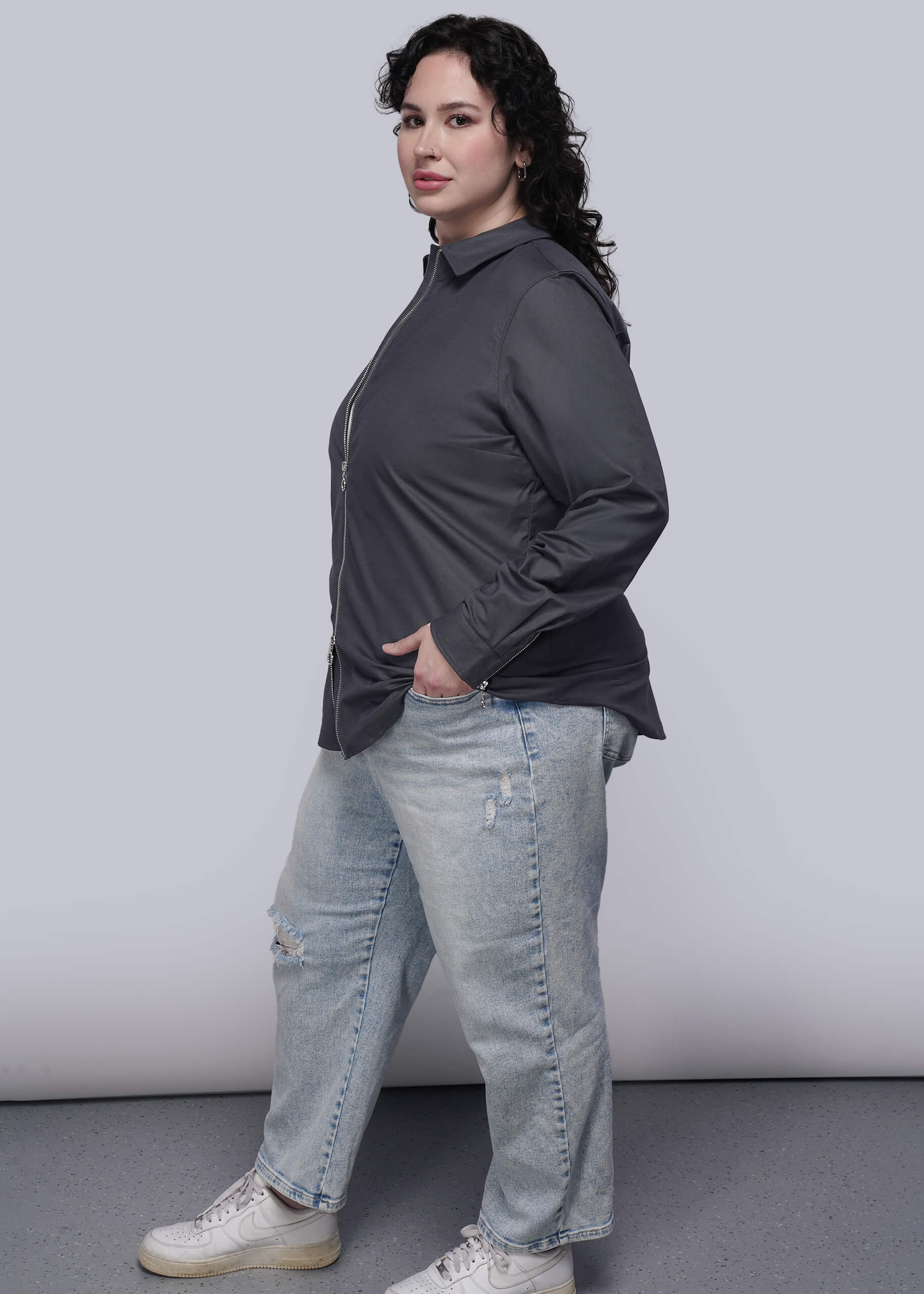 1X=Person wearing a black shirt and light blue jeans against a plain background