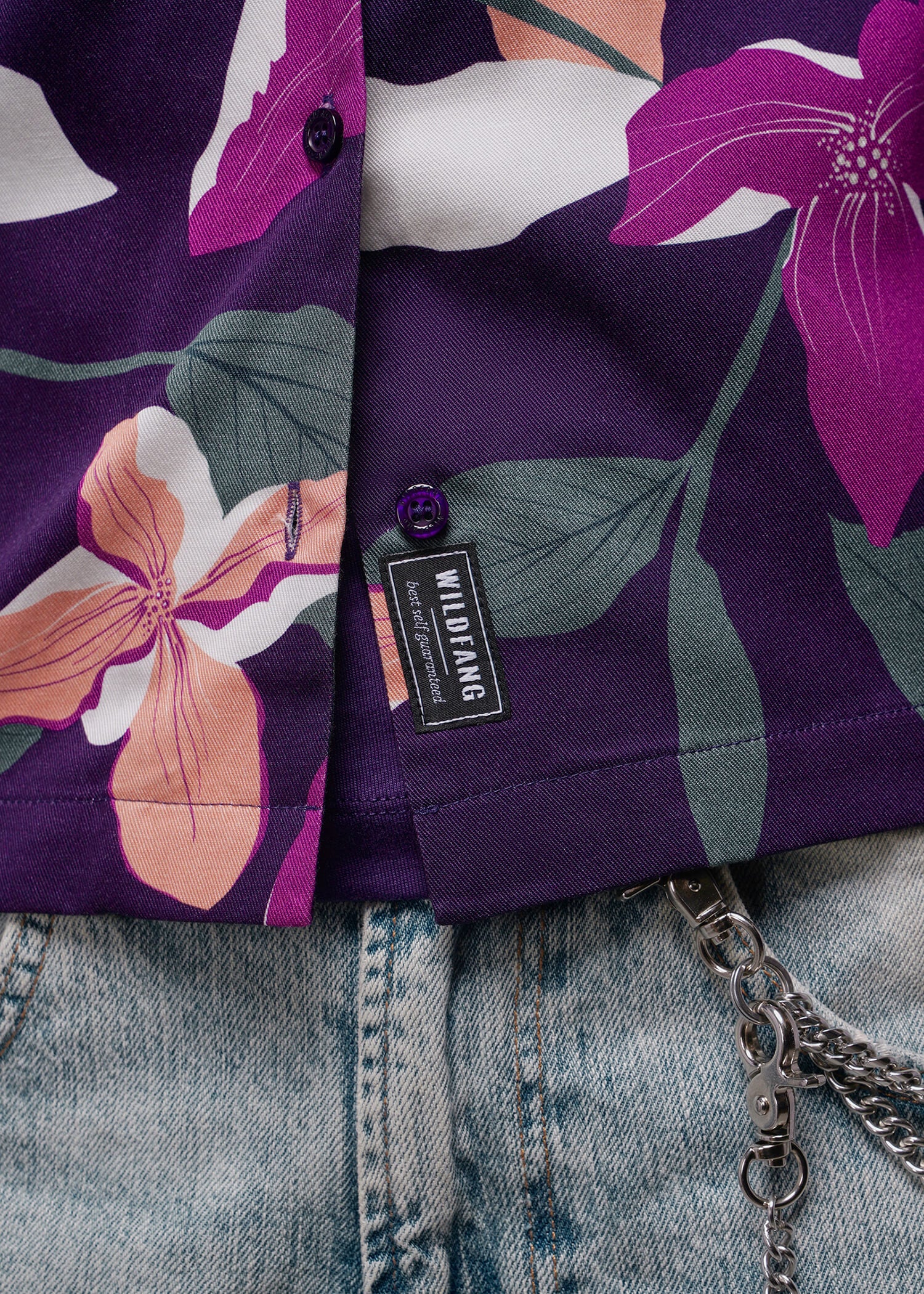 S=Floral-patterned shirt with a brand tag on a denim background