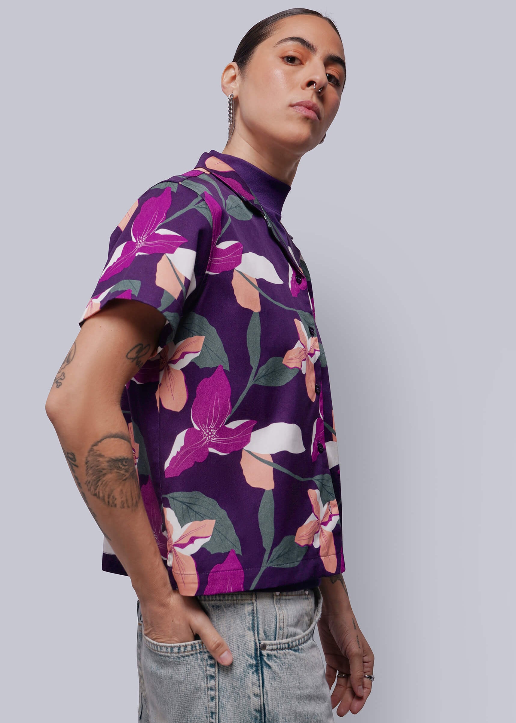 S=Person wearing a purple floral patterned shirt against a plain background