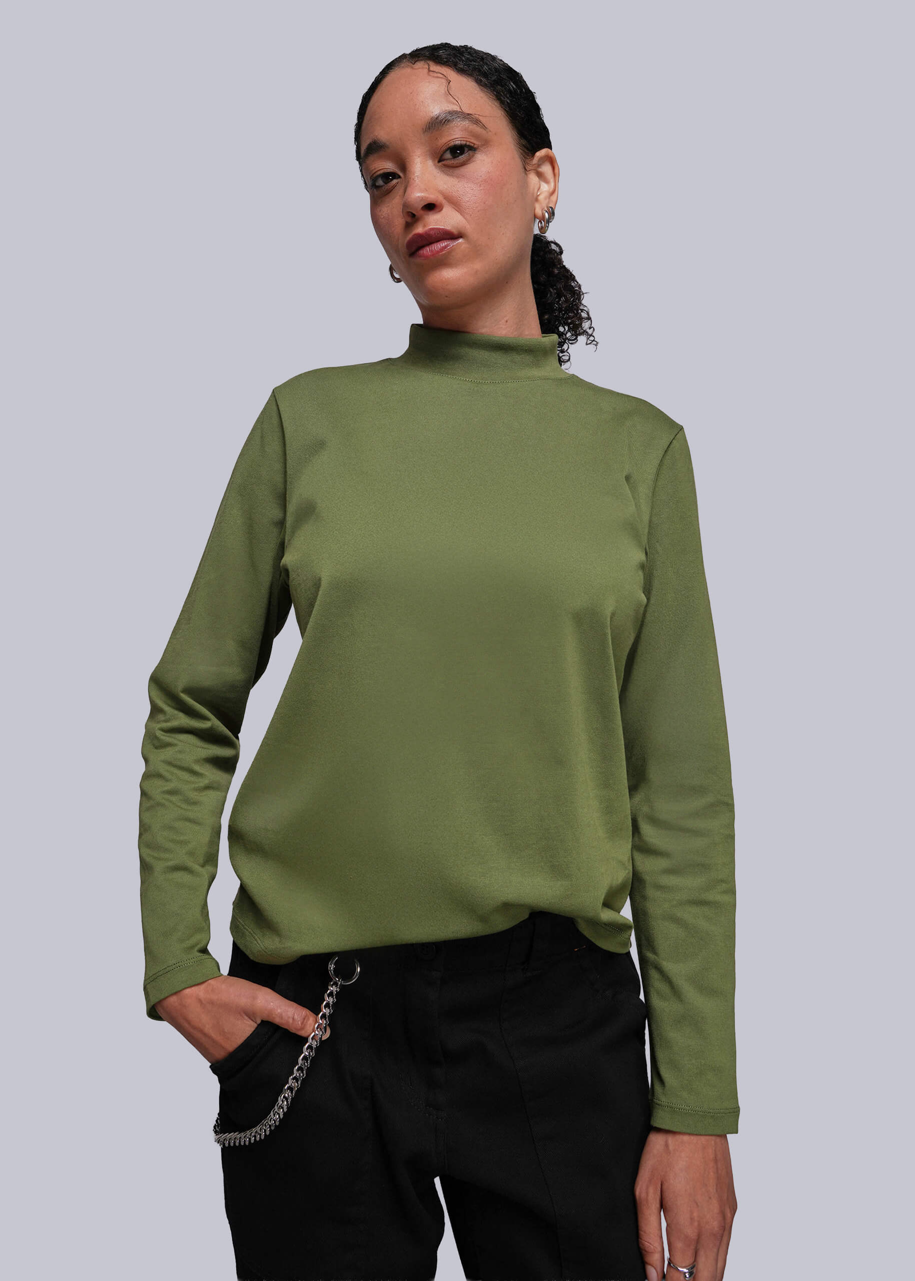 S=Person wearing a green long-sleeve top against a plain background