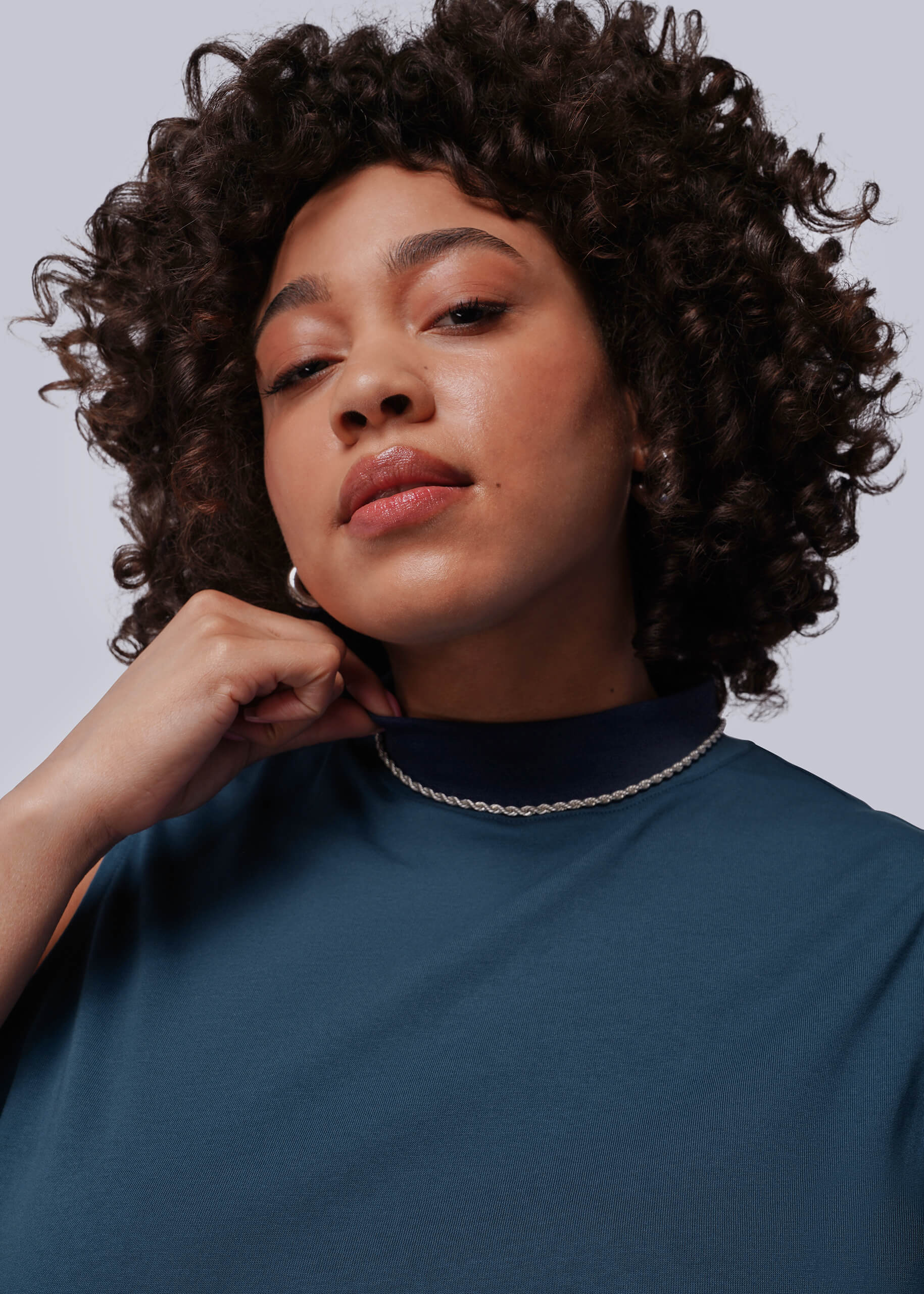 1X=Person wearing a blue top with a plain background