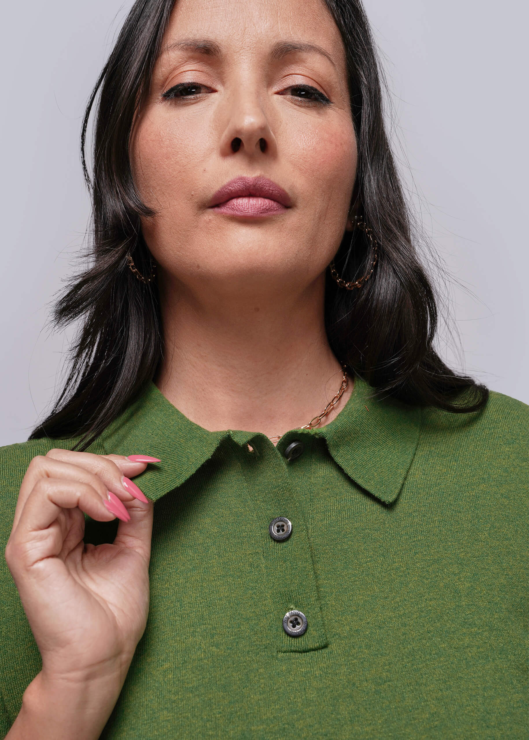 S=Woman wearing a green shirt with a plain background