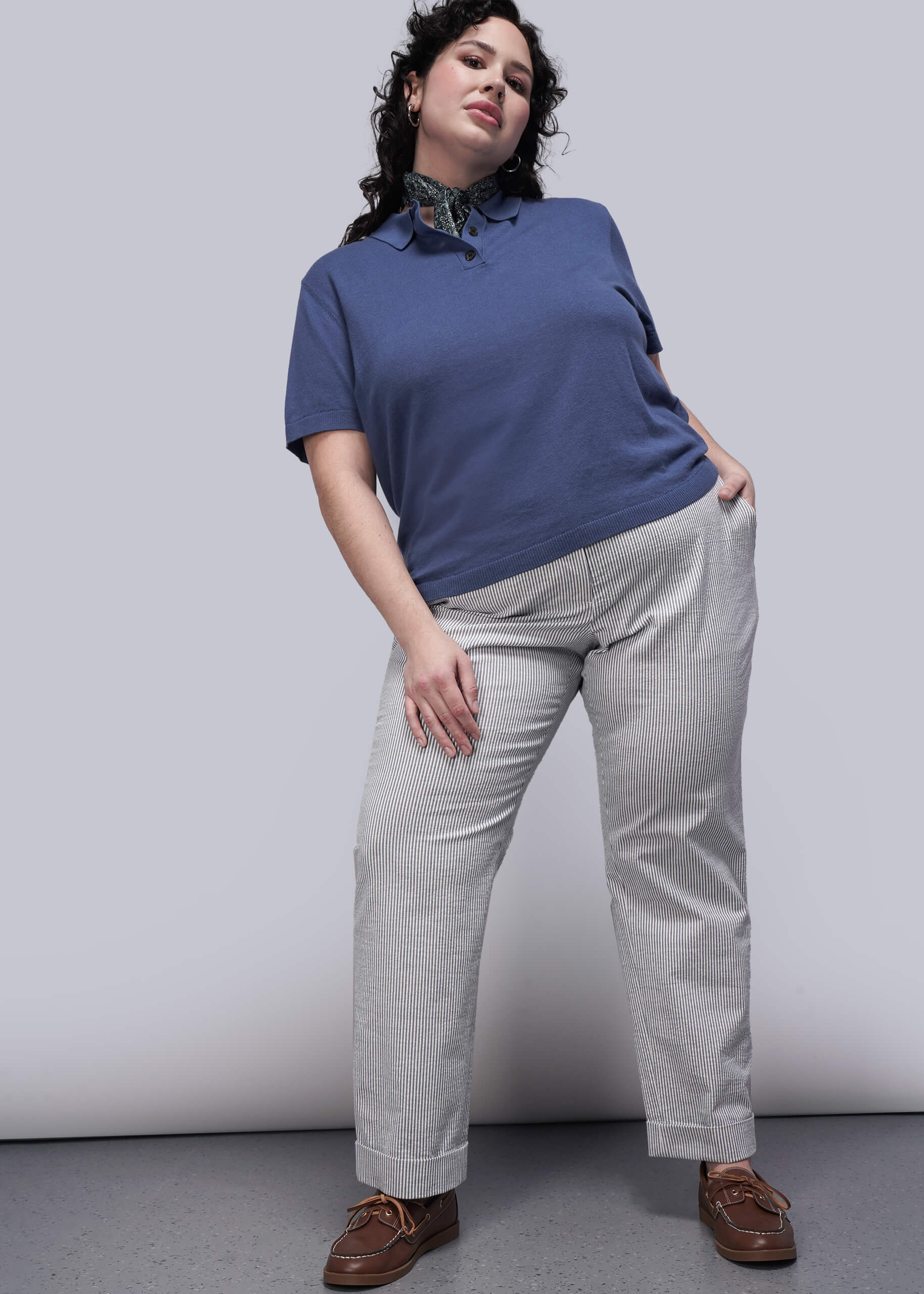 1X=Person wearing a blue shirt and gray pants against a white background