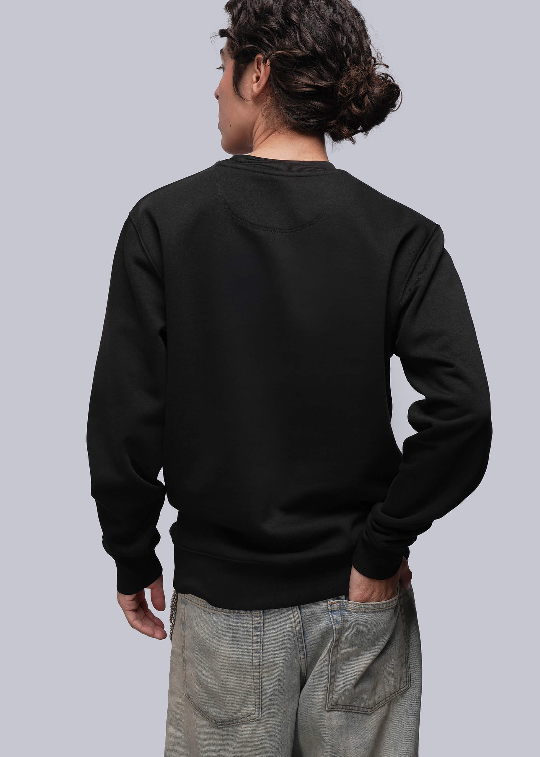 S=Person wearing a black sweatshirt with a plain background