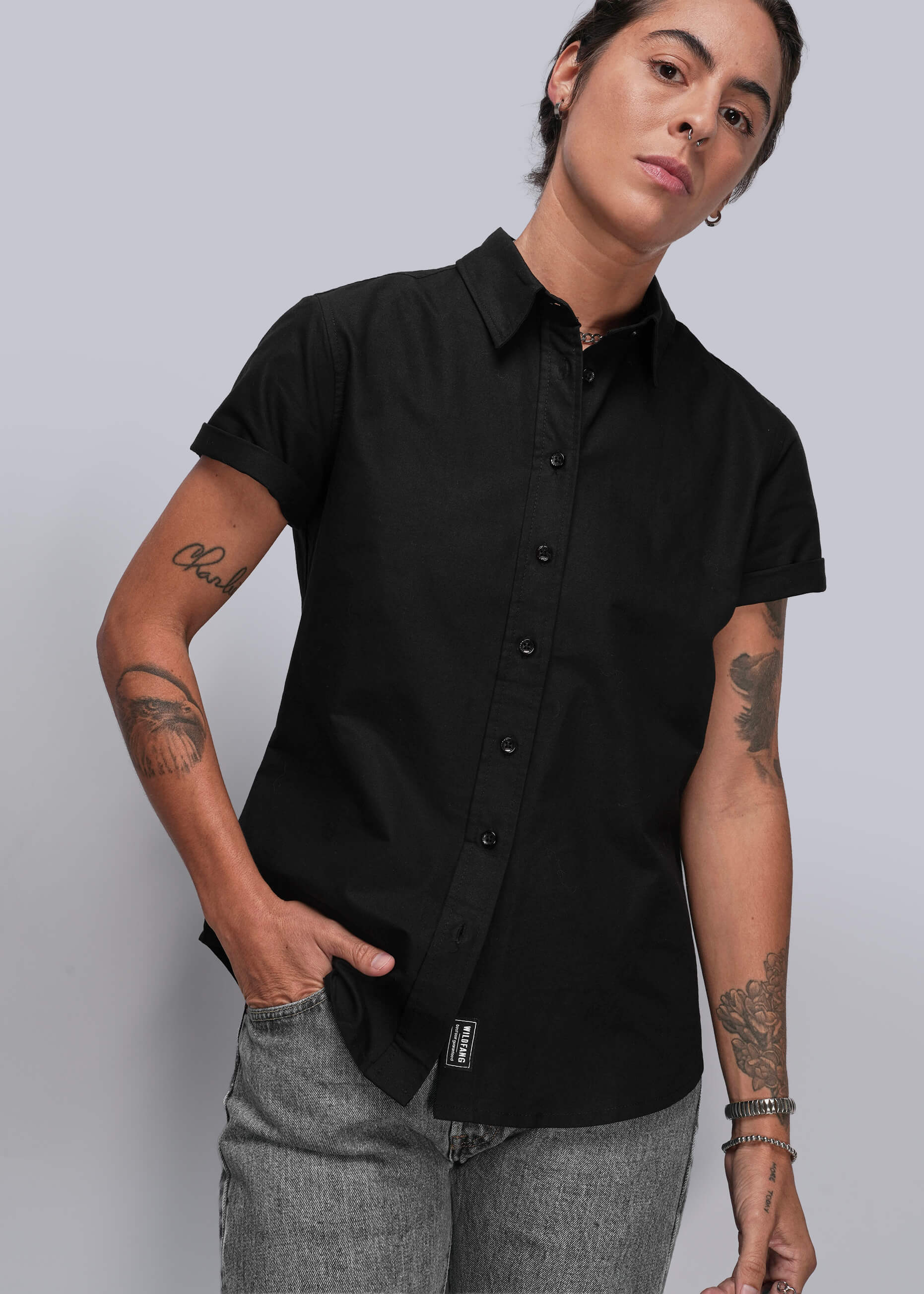 Person wearing a black short-sleeve shirt against a plain background