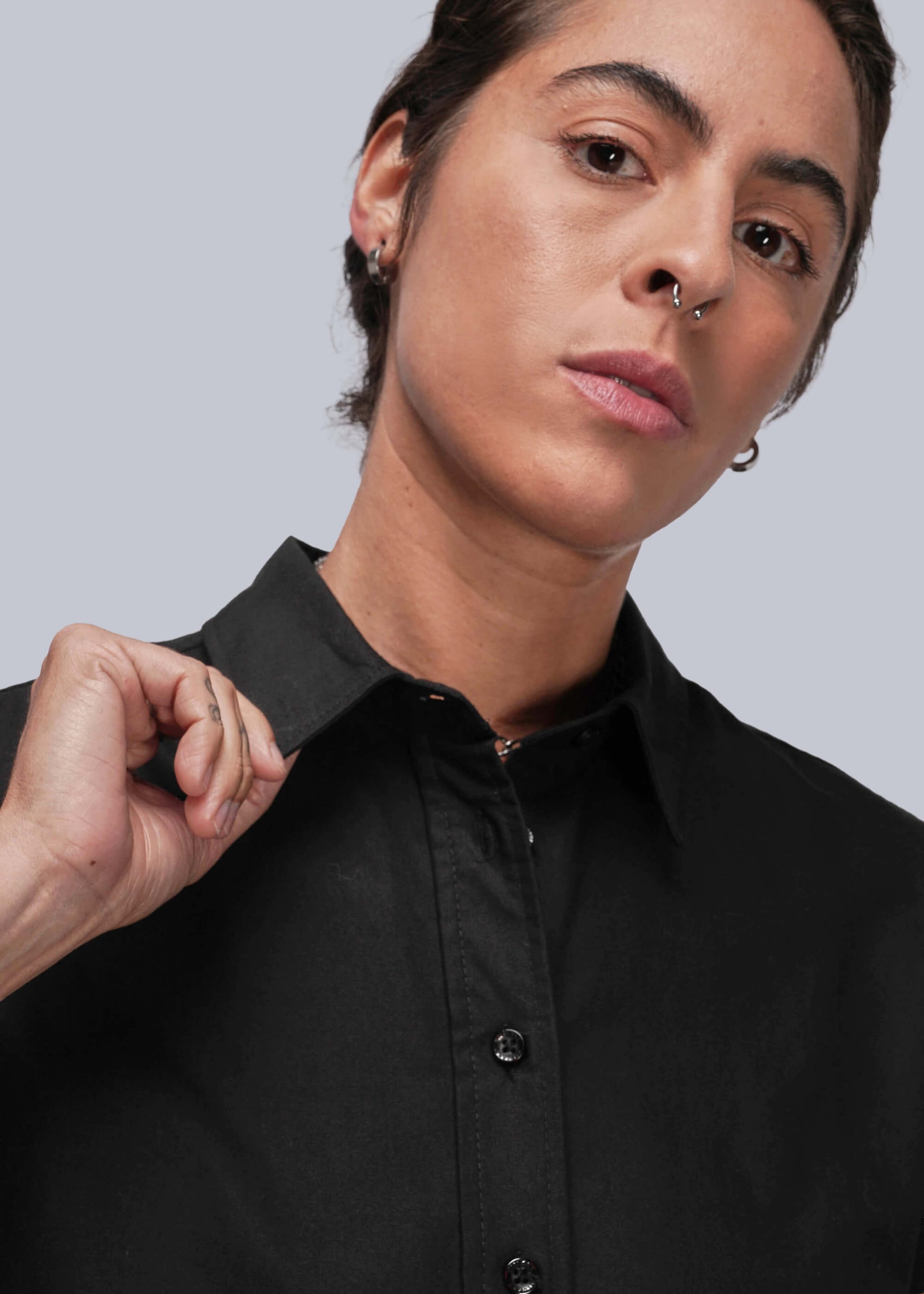 S=Close up of person wearing a black shirt against a light gray background