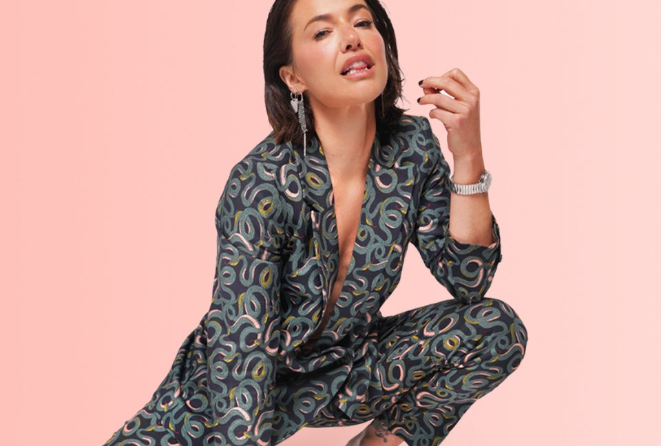 Parvati Shallow wears the Serpentine suit against a peach color background