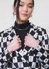 Video of two models of different sizes wearing The Peanuts x Wildfang Double Breasted Blazer. Video shows close ups of the lapel, inside and outside pockets, and the custom black and white checkered print featuring Peanuts characters.